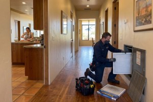 Indoor air quality technician servicing whole-home air filter