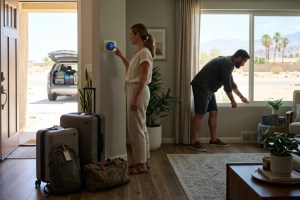 Couple preparing smart home cooling settings before summer trip