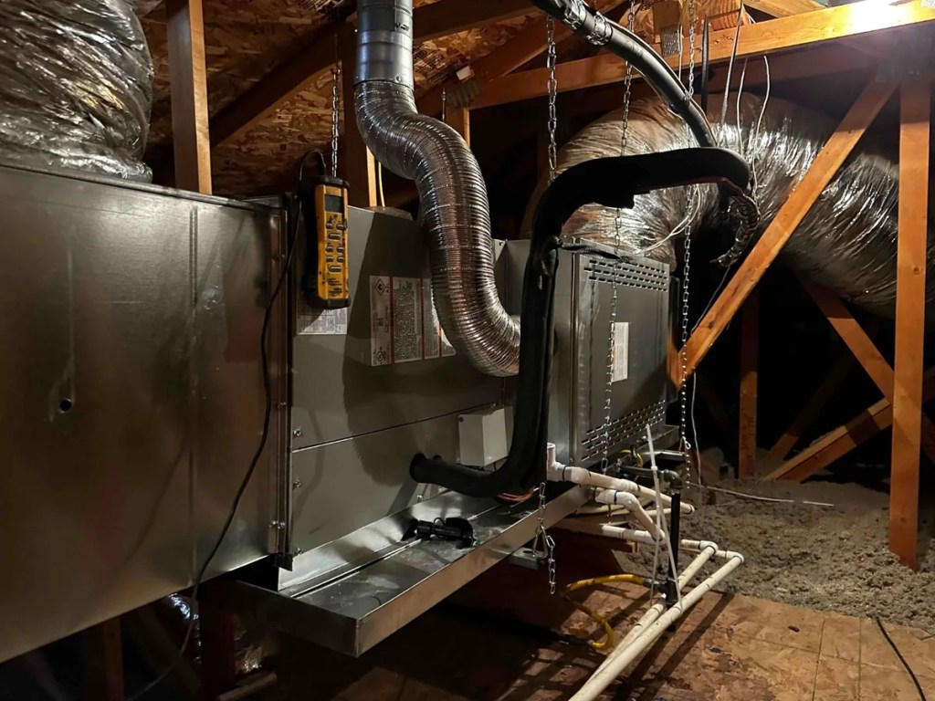 Technician evaluating central ductwork for heating zones