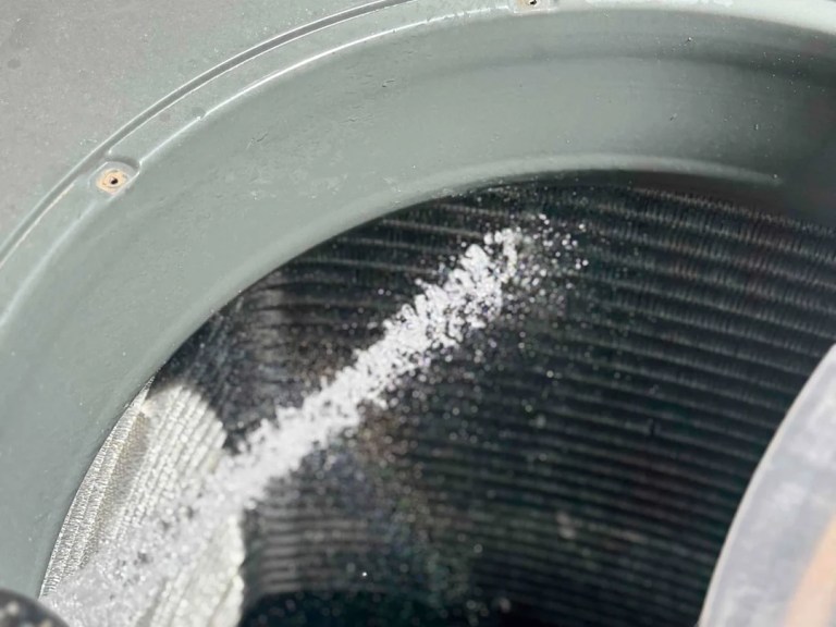 AZ Perfect Comfort technician rinsing a dirty air conditioner condenser coil during a tune-up