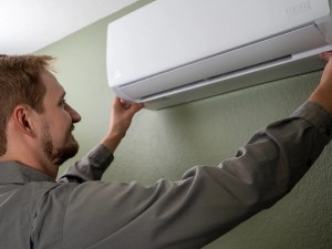 AZ Perfect Comfort technician mounting a ductless mini-split indoor head on a wall