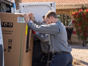 AZ Perfect Comfort installers unloading a new American Standard air handler at a Phoenix home