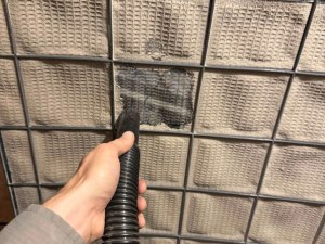 AZ Perfect Comfort technician vacuuming a clogged return air filter screen