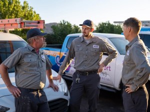 AZ Perfect Comfort technicians talking beside company service trucks