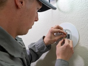 AZ Perfect Comfort technician testing a home thermostat during a maintenance visit