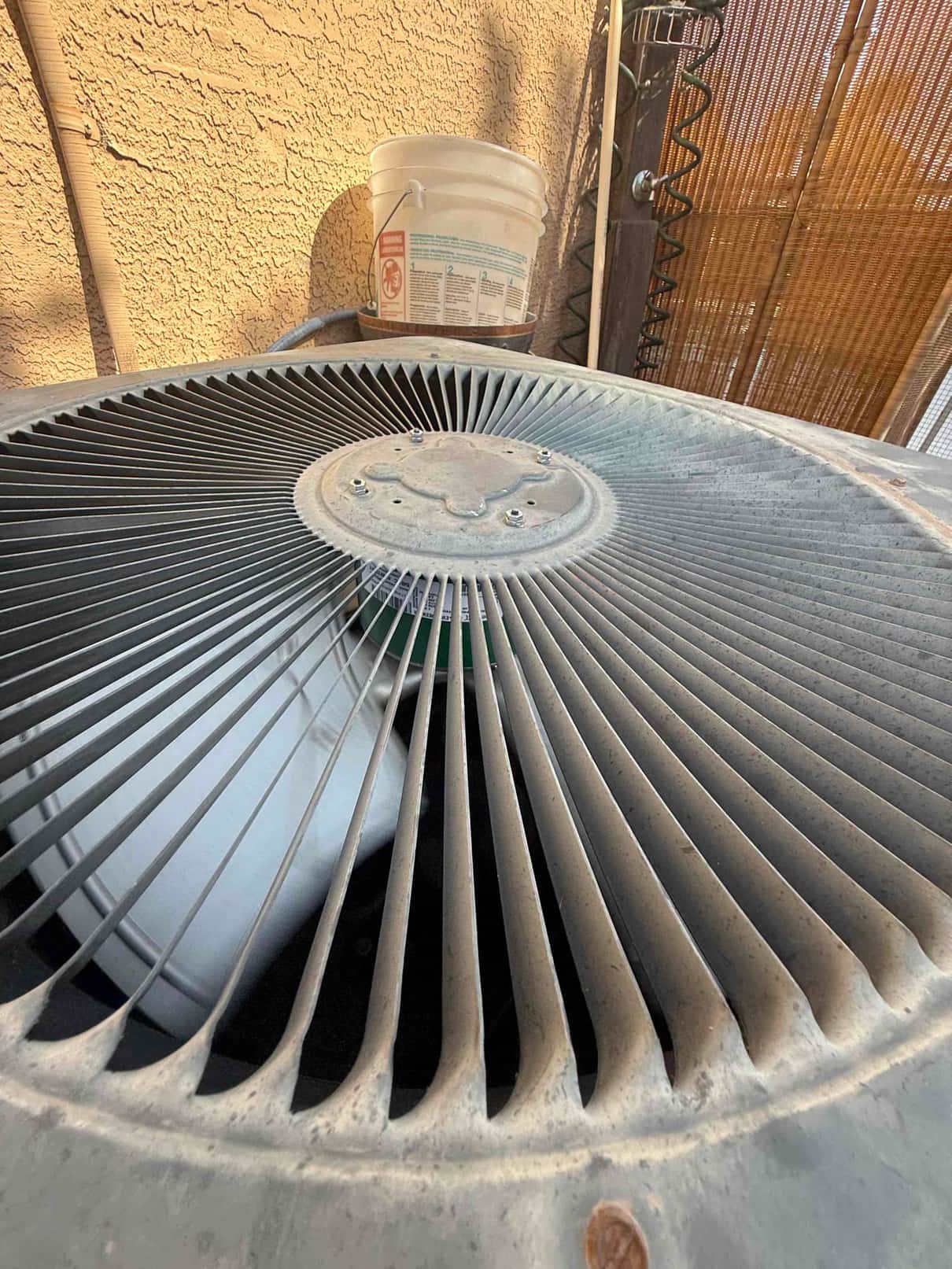 Condenser fan motor showing heavy dust accumulation on the blades and housing.
