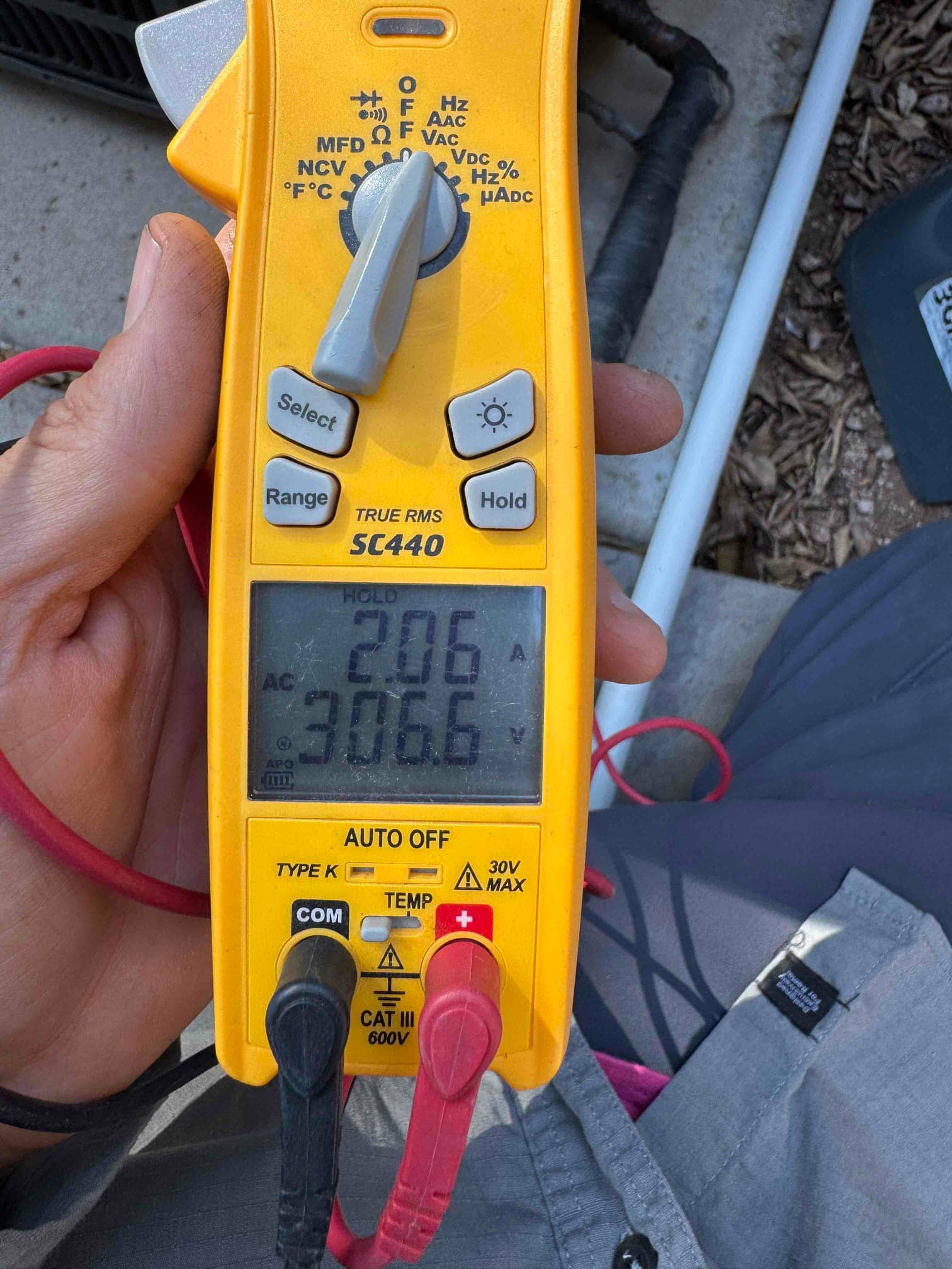 Clamp meter displays 2.06 A AC current on a clamped conductor during air conditioning service testing.