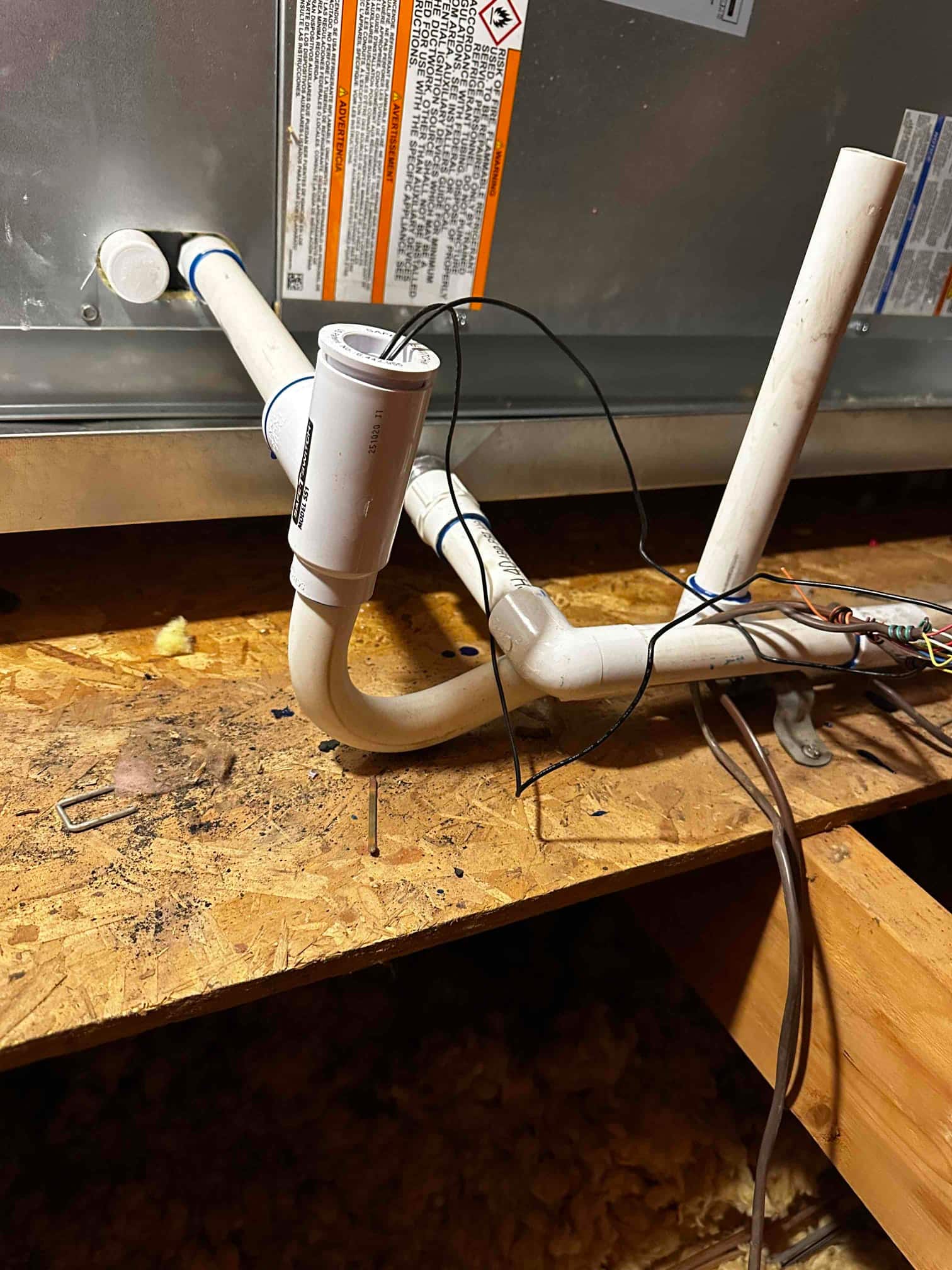 Condensate drain assembly at the air handler with trap, cleanout, and float safety switch wired to shut off on overflow.