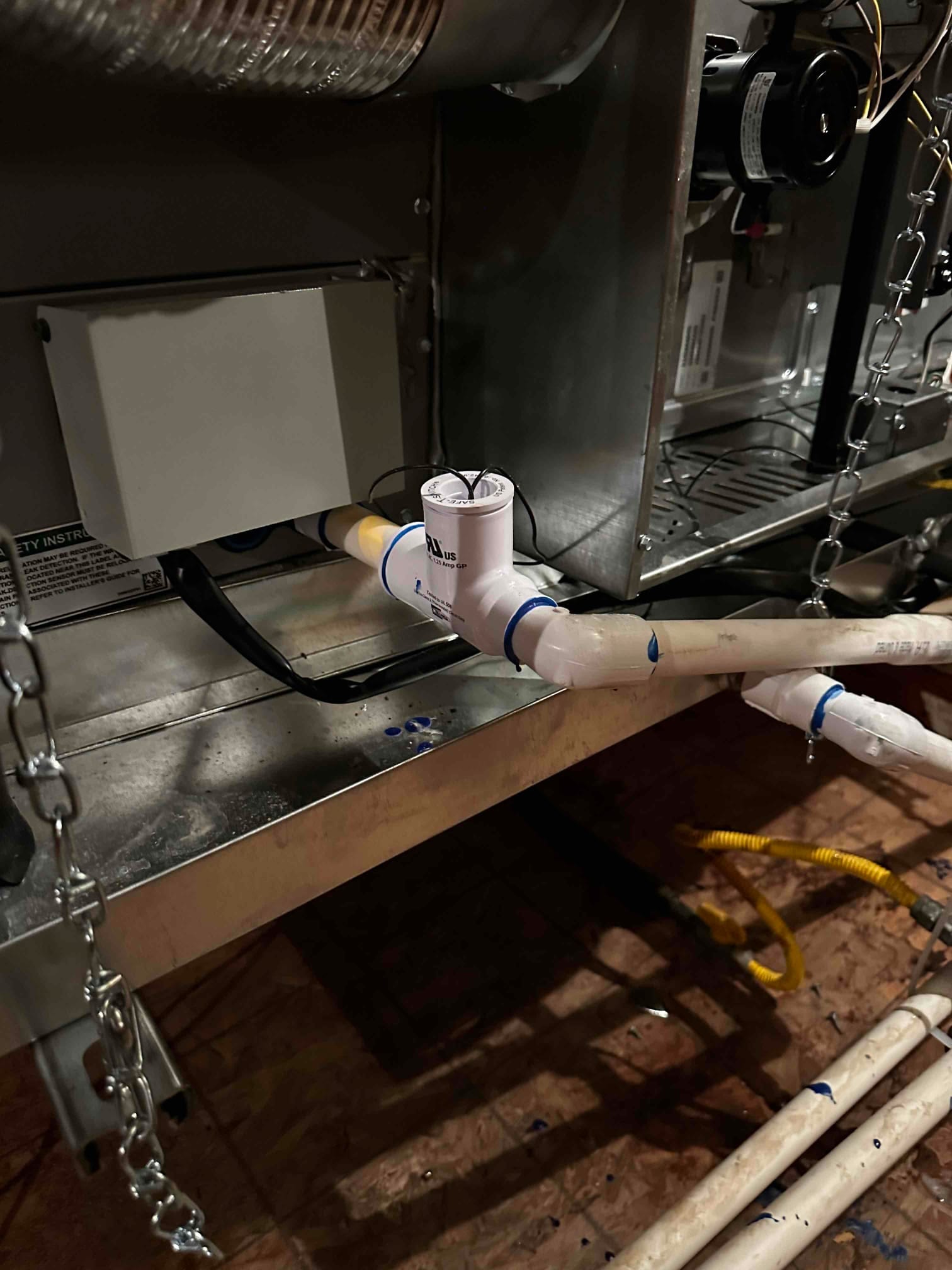 Condensate drain assembly with float switch wired to shut off, installed beneath an air handler with sealed PVC piping.