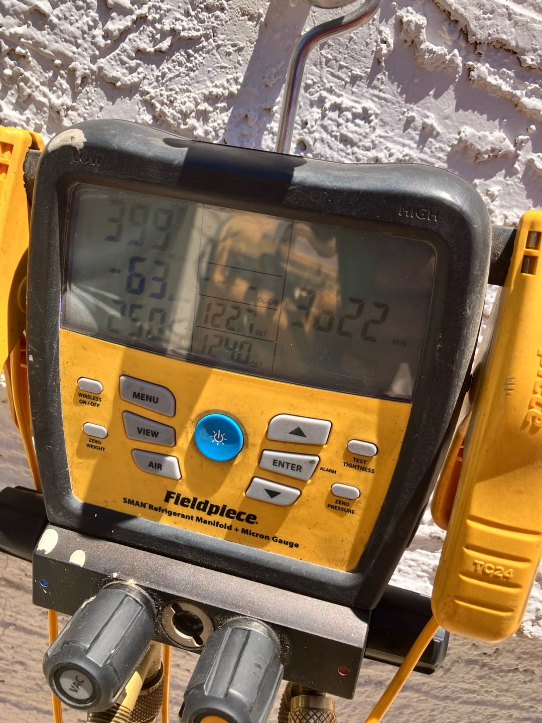 Digital manifold gauges display equal high pressure on both sides during a nitrogen pressure test of the new mini-split installation.