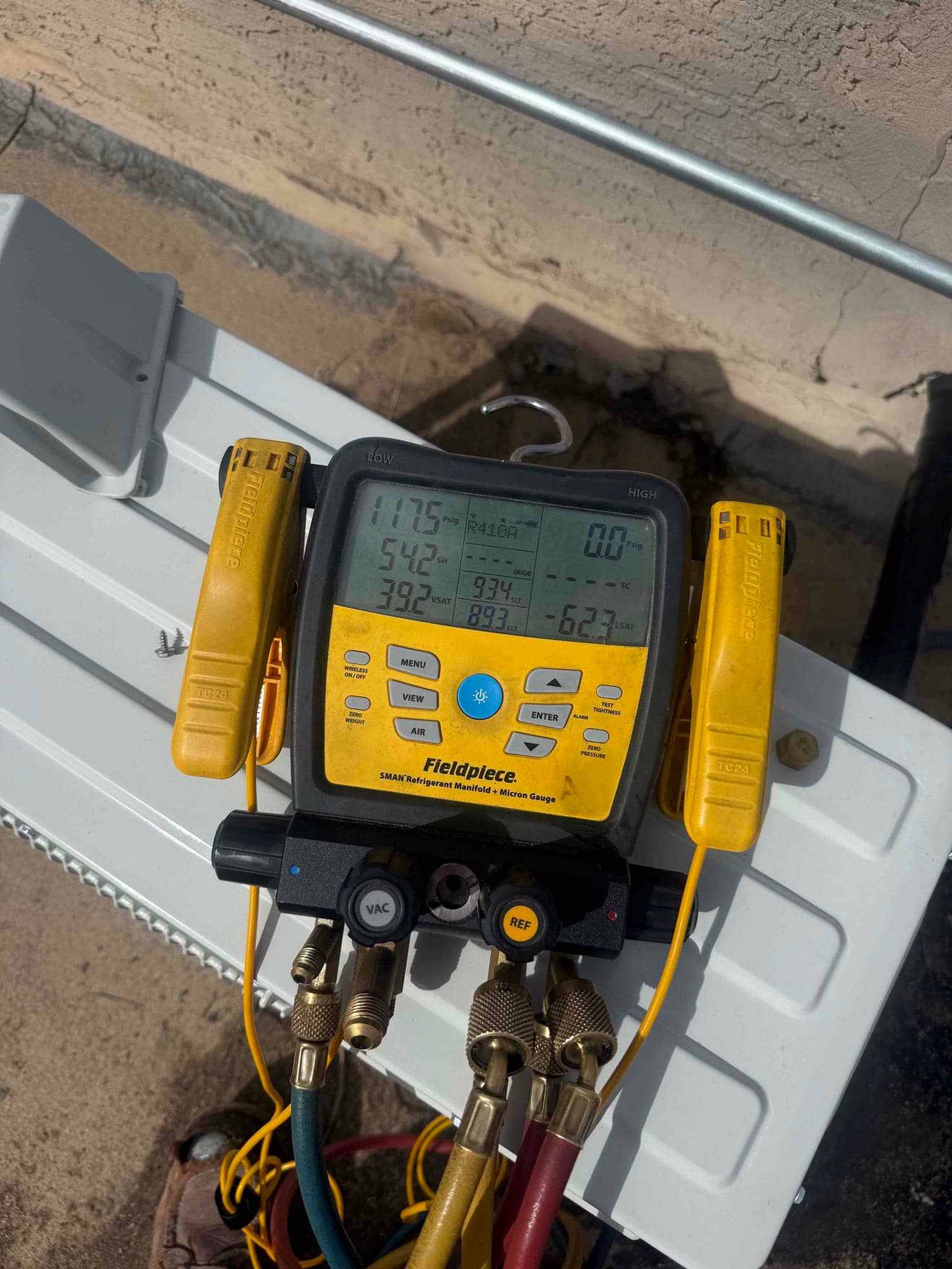 Digital manifold gauges show equal high pressure on both sides during a nitrogen pressure test of the mini‑split installation.