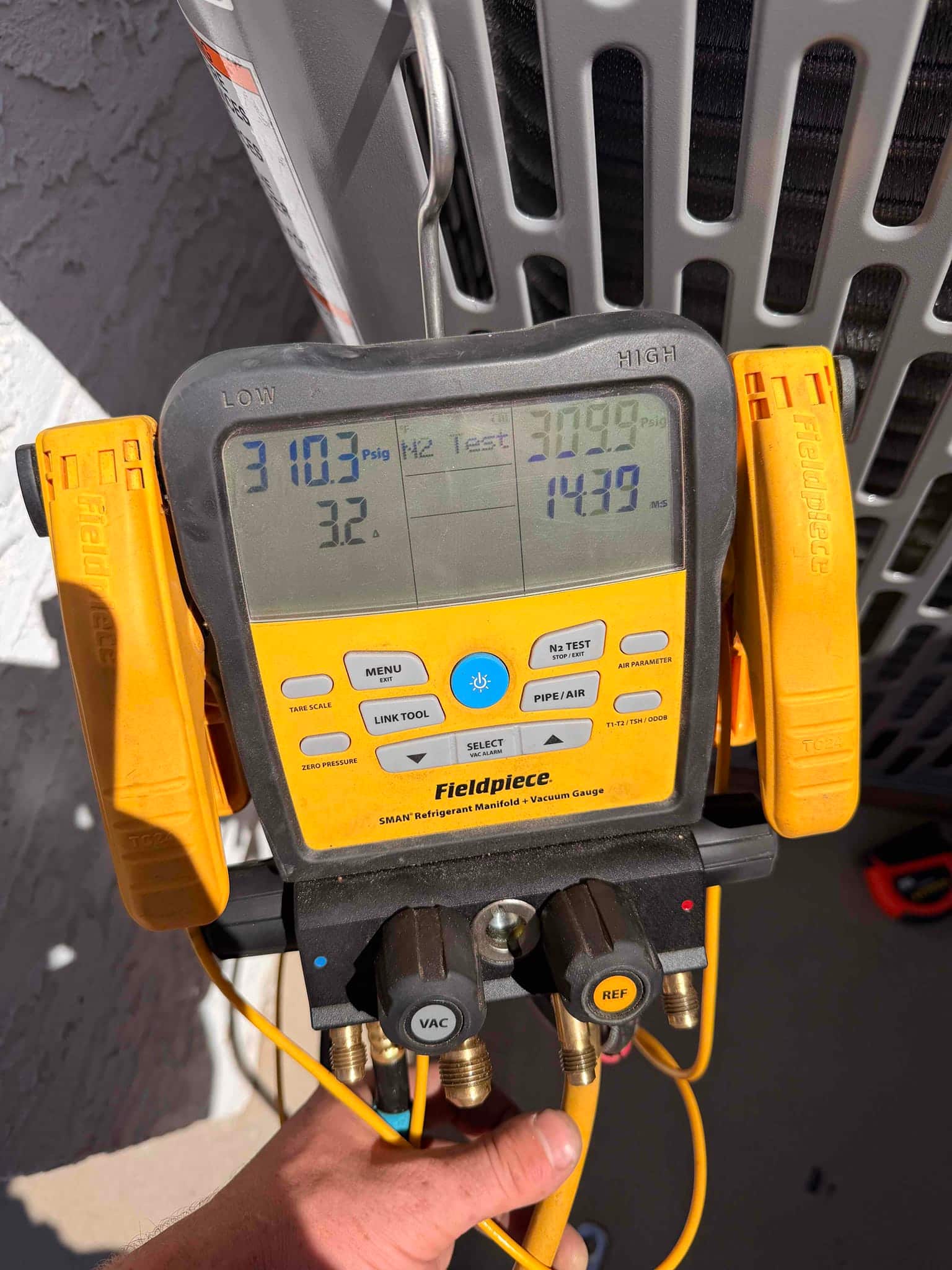 Digital manifold shows both sides holding near 310 PSI during a nitrogen pressure test on the newly installed system.