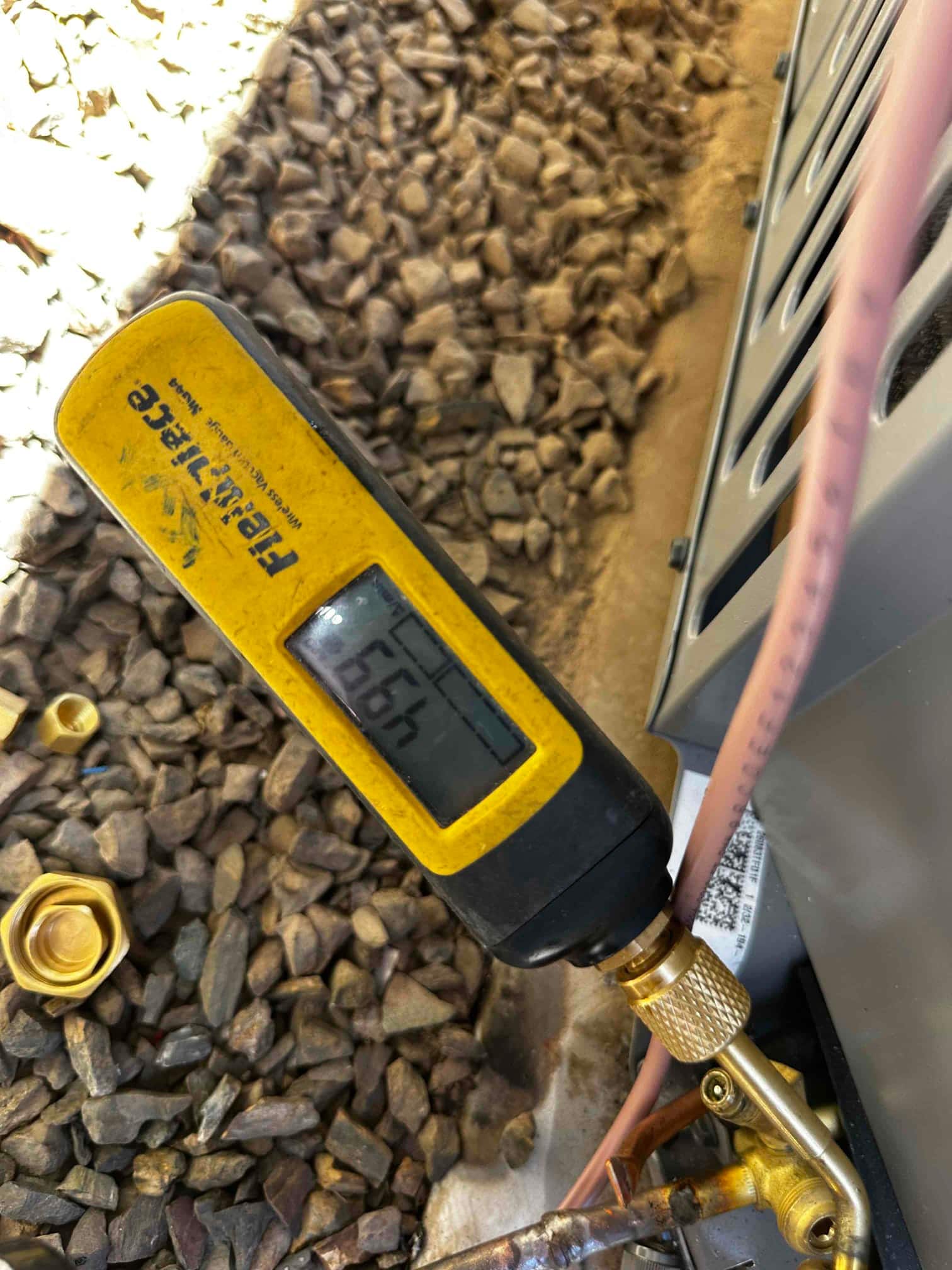 Digital micron gauge connected at the service port shows 266 microns during the system evacuation before refrigerant charging.