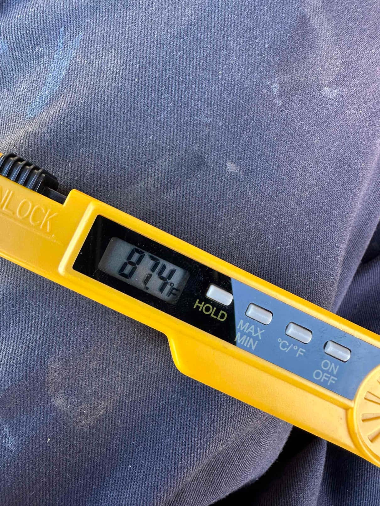 Digital thermometer displays 87°F during air temperature check as part of startup commissioning.