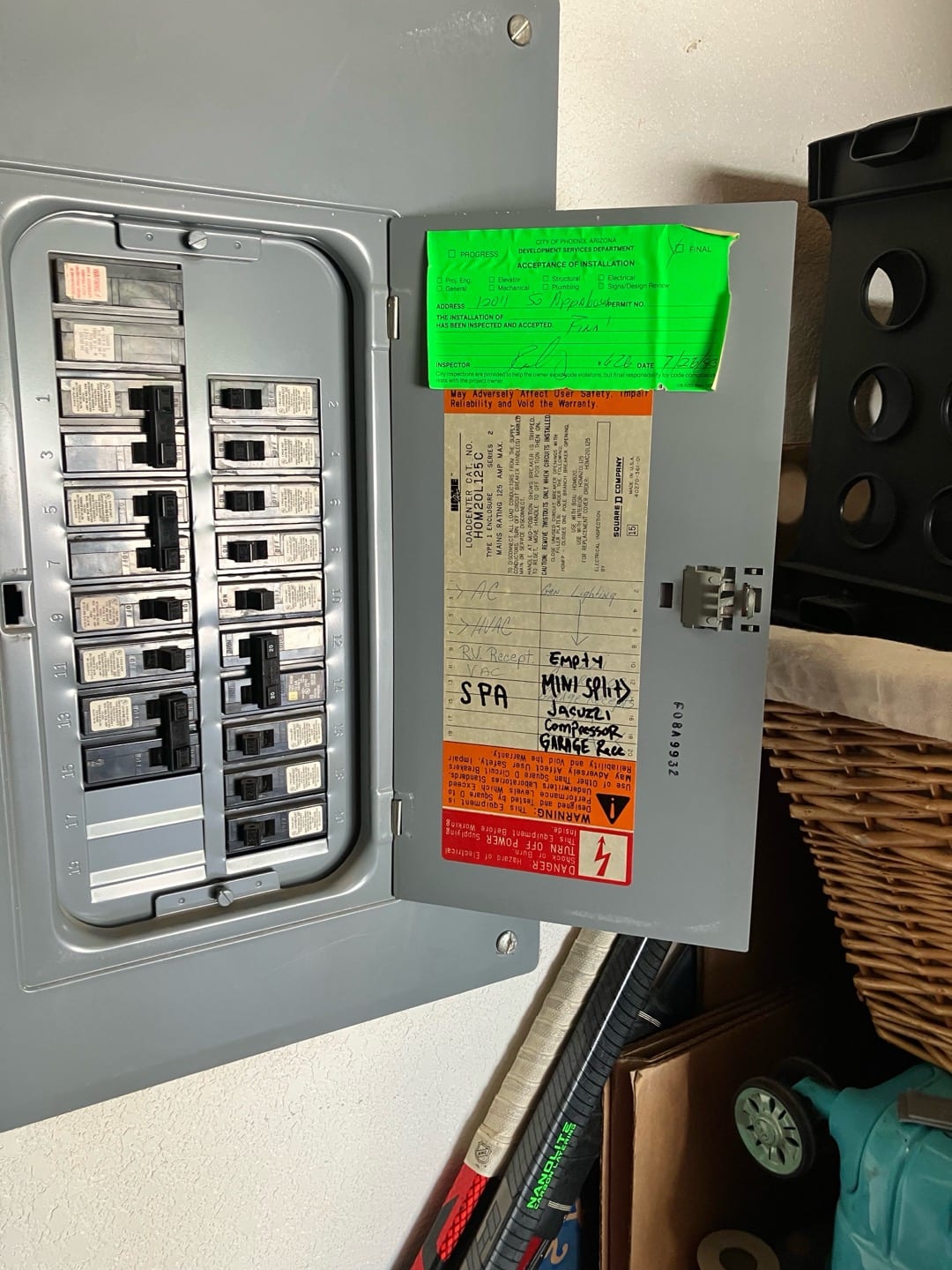 Open electrical panel with labeled breakers visible on the door, documenting circuit identification for the new mini-split installation.