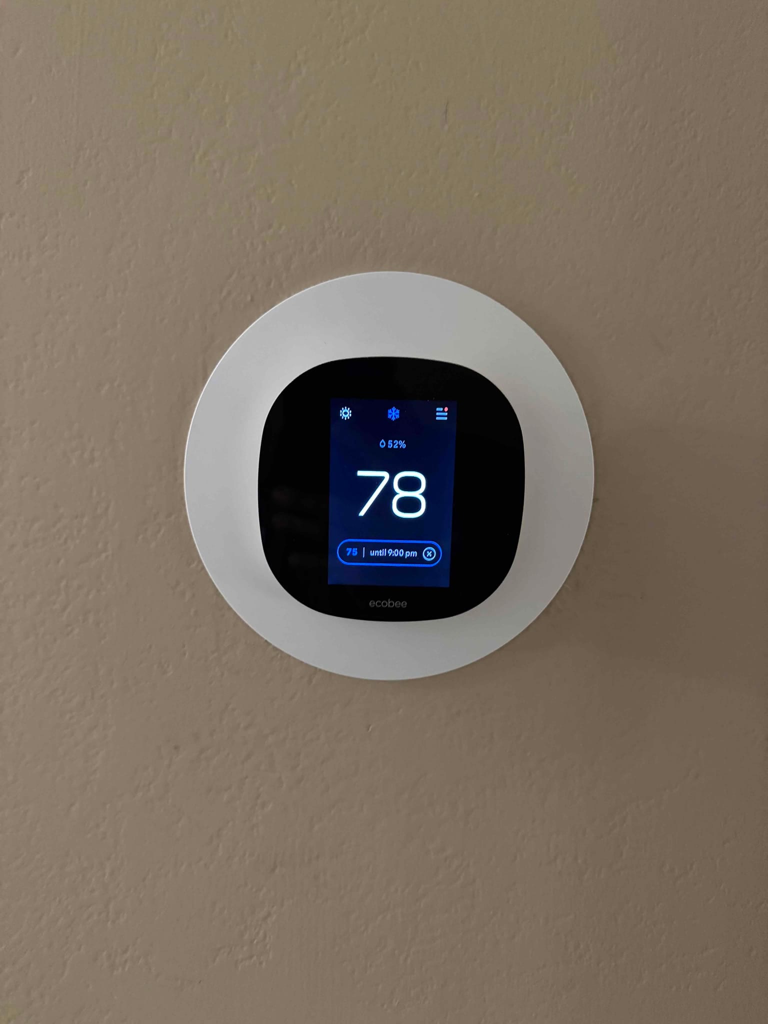 Wall-mounted smart thermostat displays indoor temperature of 78 degrees with cooling mode active and fan set to auto.