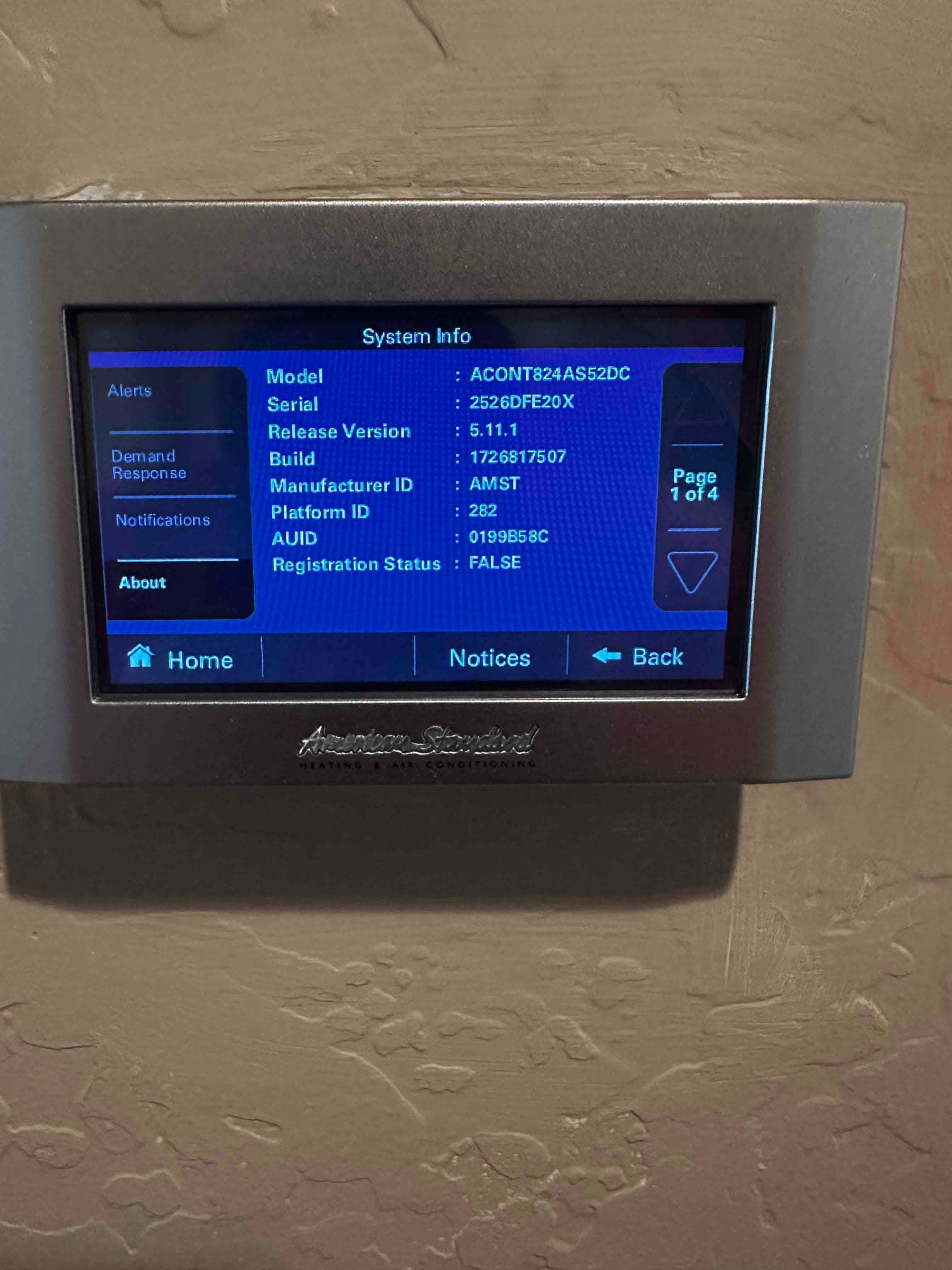 Wall-mounted thermostat displays system information menu with model and software details after new HVAC installation.