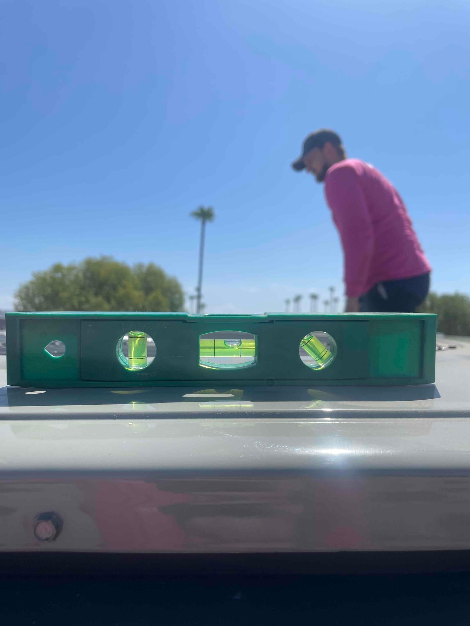 Bubble level on top of newly installed equipment cabinet, confirming the unit is set level on its mounting surface.