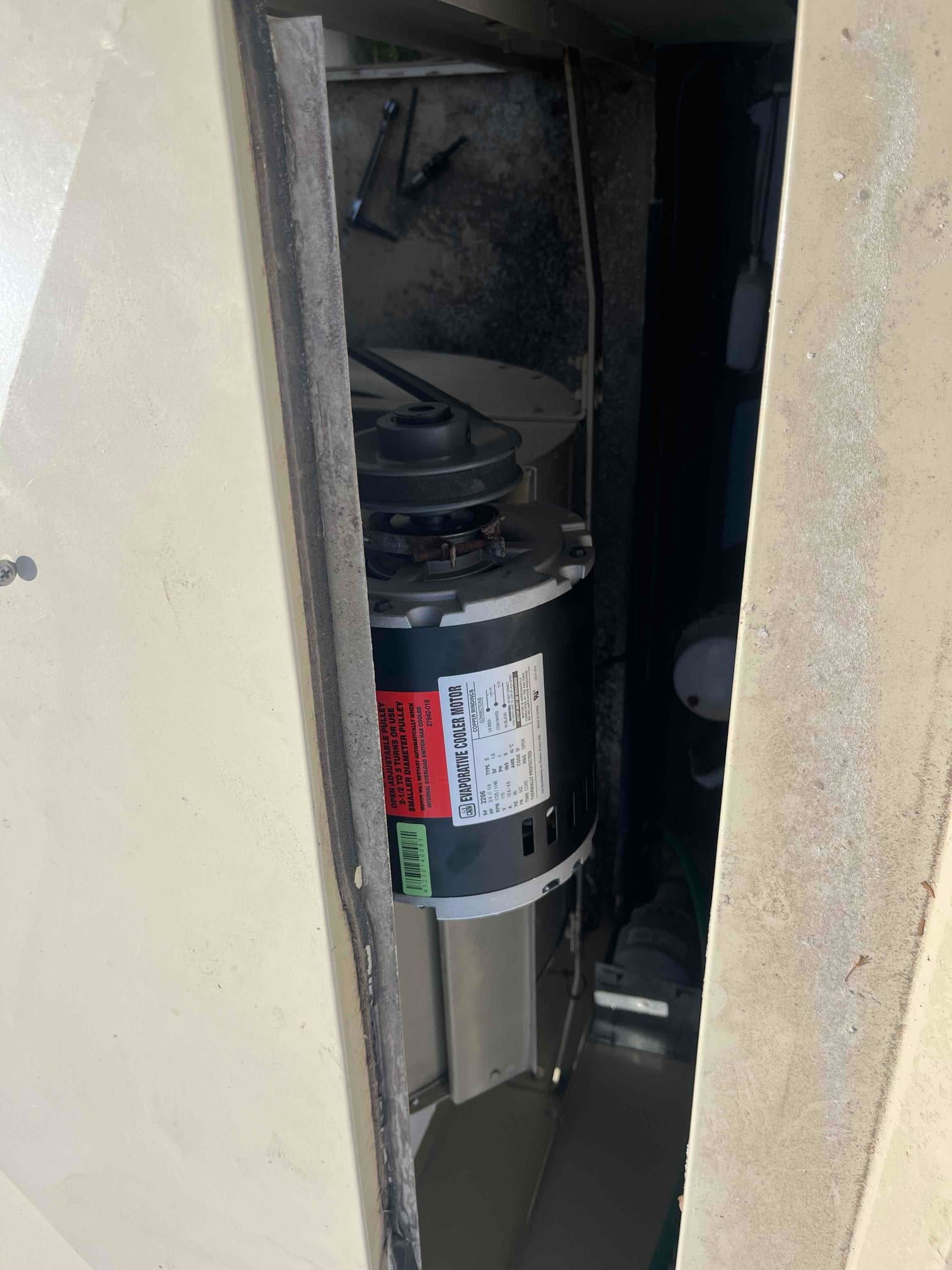 Evaporative cooler blower motor installed inside the housing, showing clean wiring connections and mounting bracket in place.