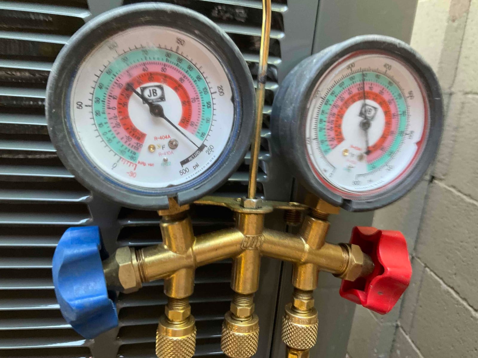 Analog manifold gauges show equal pressure on both sides during a nitrogen pressure test of the newly installed system.