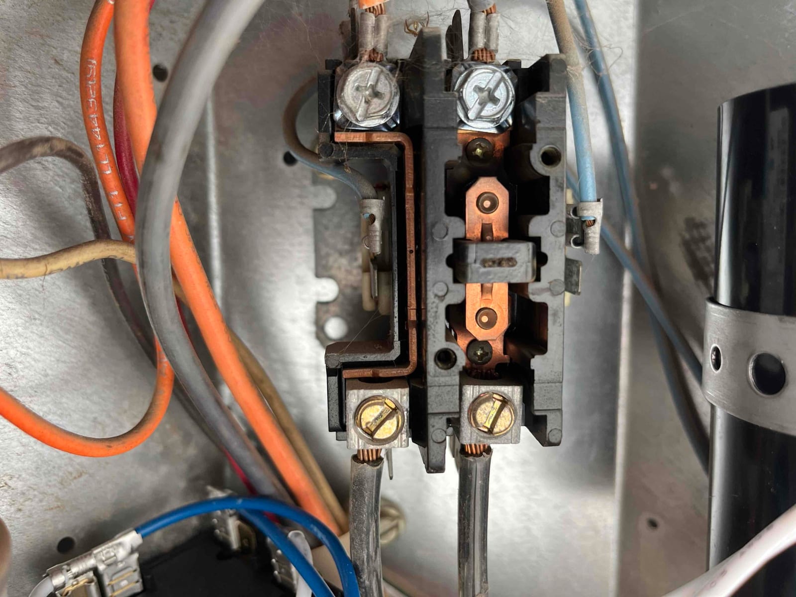 Contactor inside the outdoor unit, showing copper contact set and secured line and load wires.