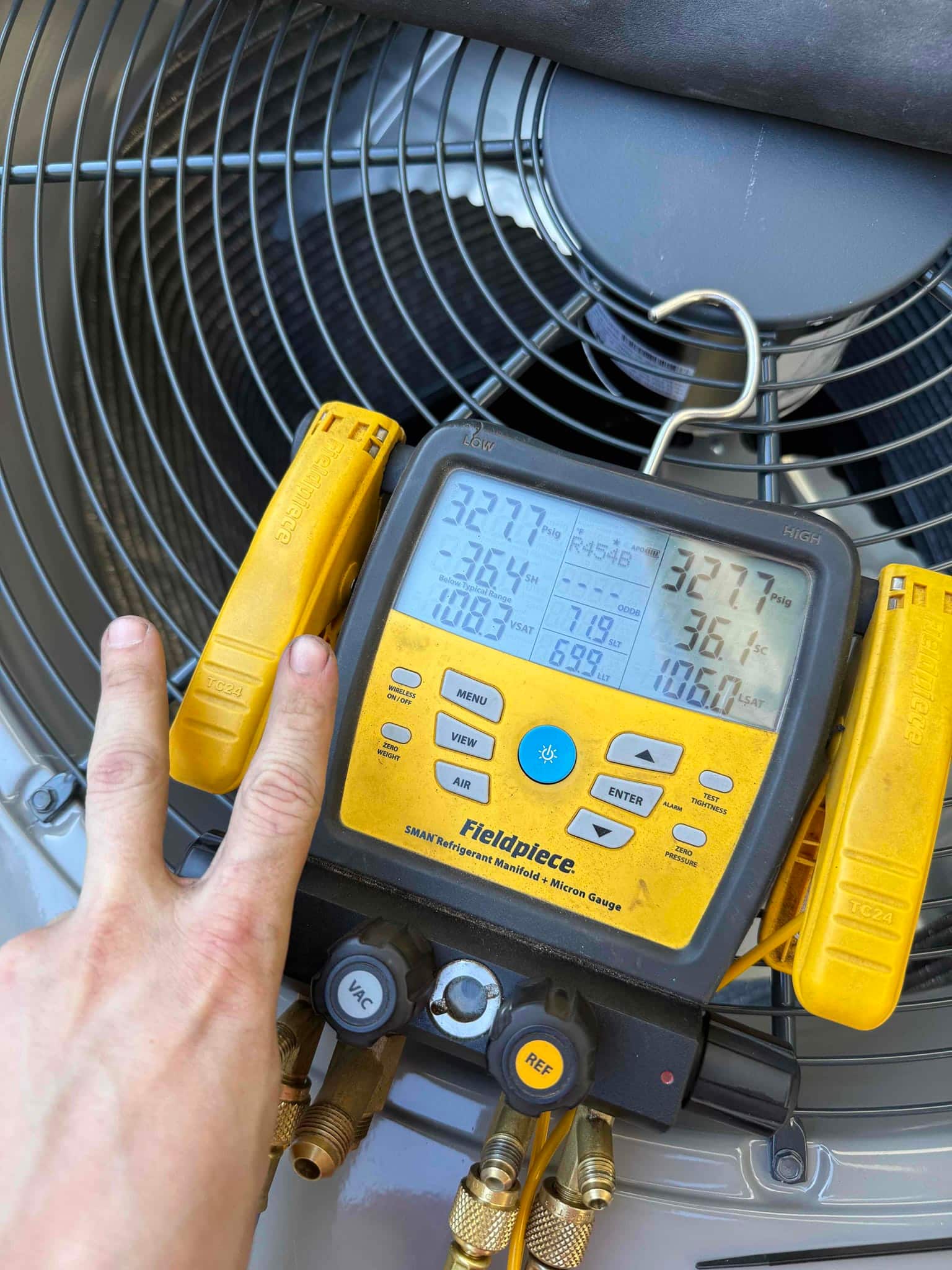 Digital manifold connected at the outdoor unit shows operating suction and liquid pressures with R-454B selected during system commissioning.