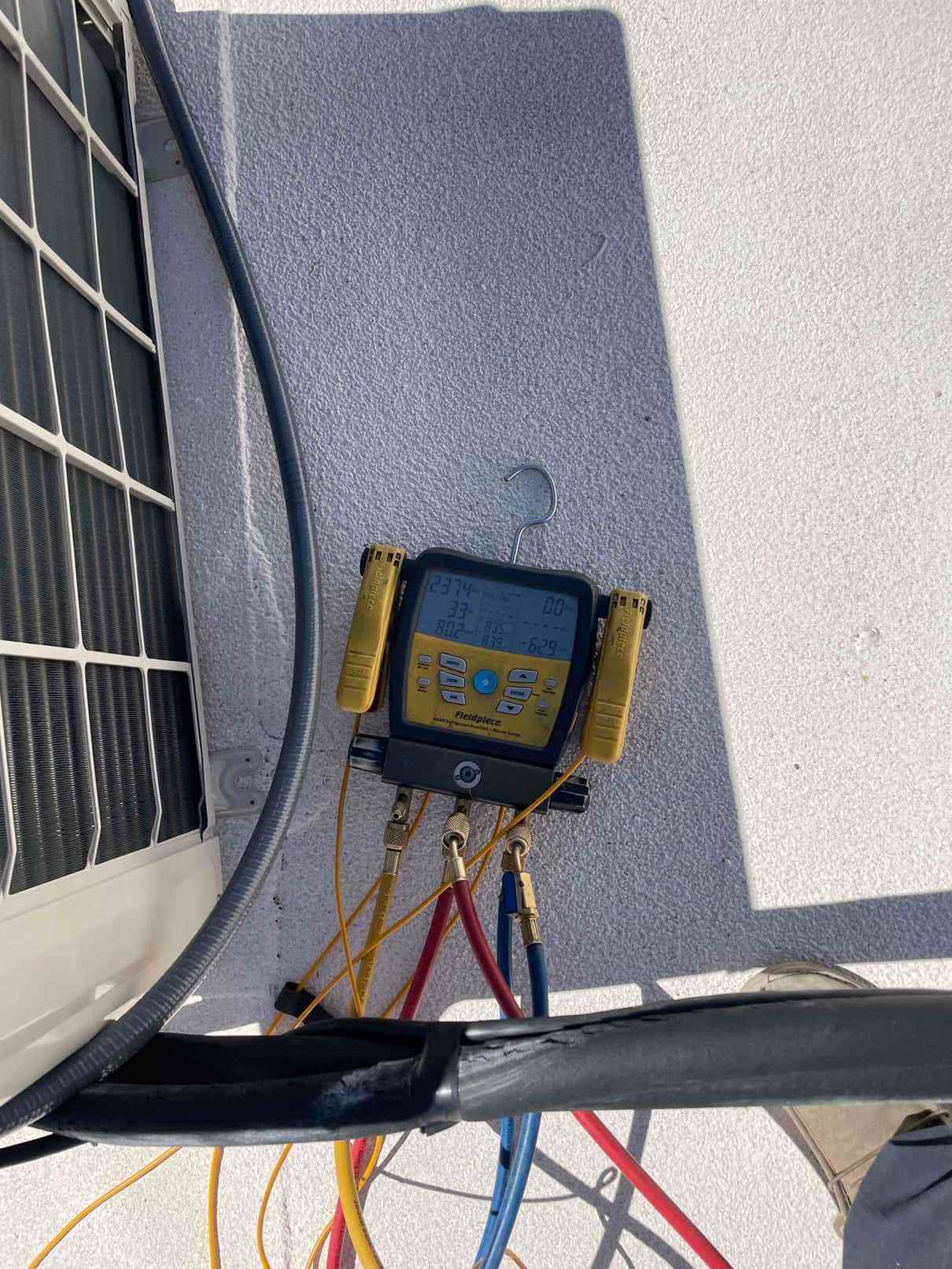 Digital manifold gauges connected to the mini‑split hold equal high pressure on both sides during the nitrogen pressure test.