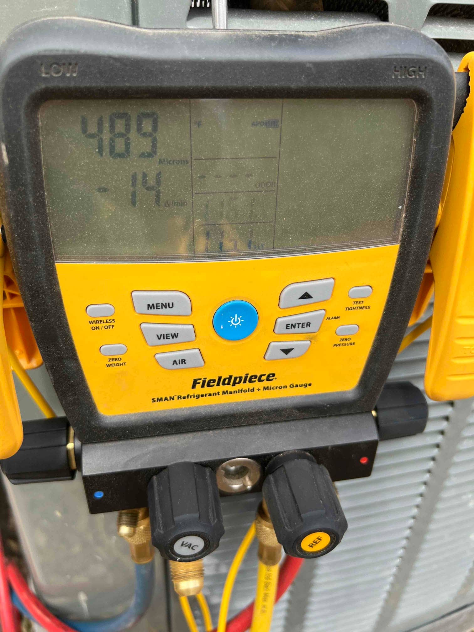 Digital micron gauge on the manifold shows 489 microns during system evacuation prior to charging refrigerant.
