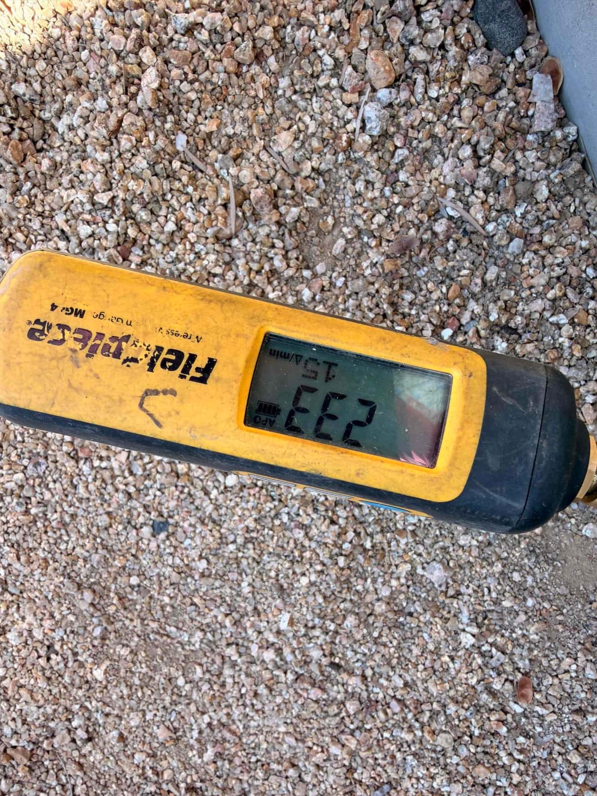 Digital micron gauge shows 232 microns during evacuation, confirming a deep vacuum before releasing refrigerant into the system.