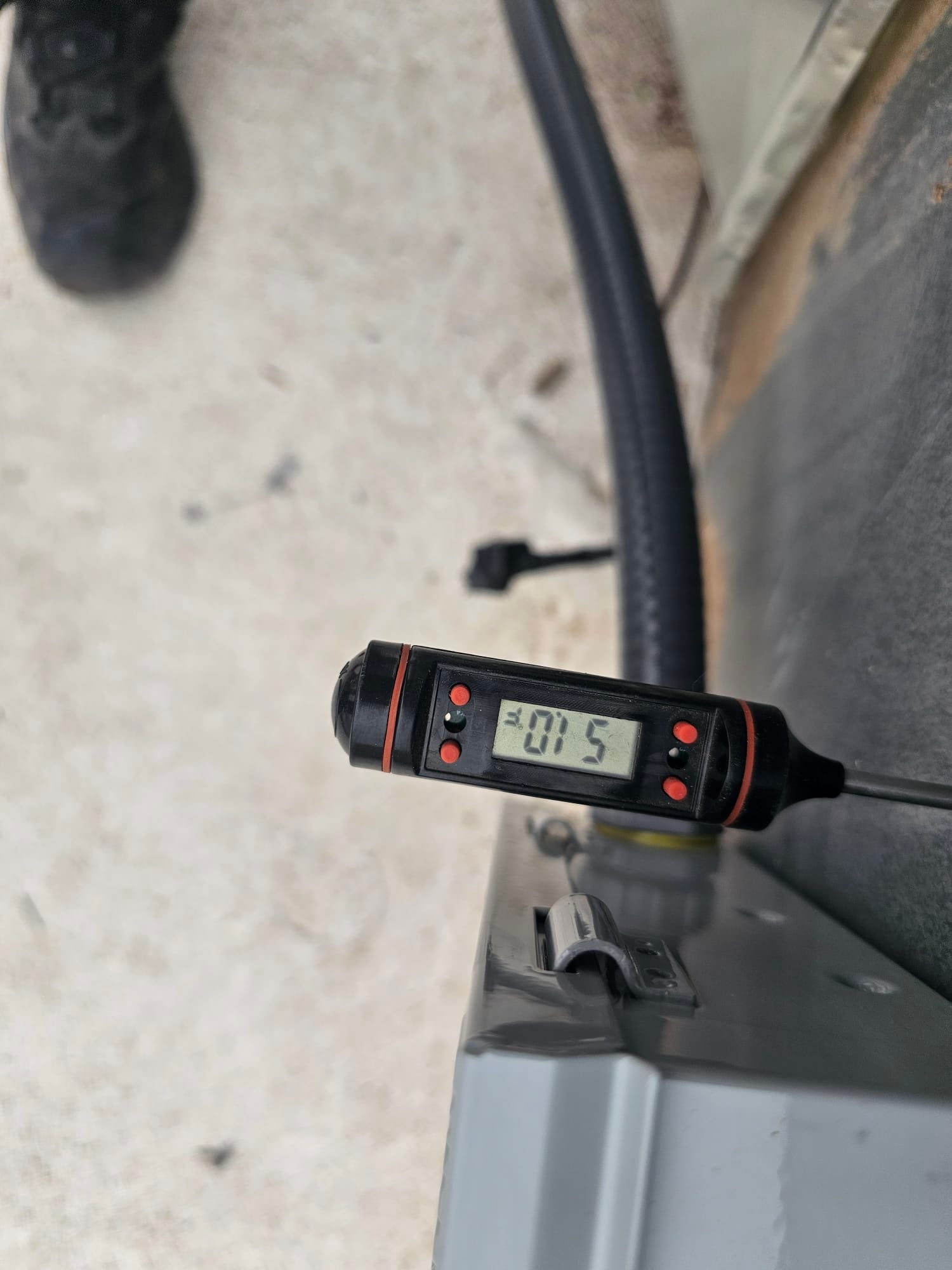 Digital thermometer inserted near the outdoor unit shows an air temperature reading of 75 degrees Fahrenheit.