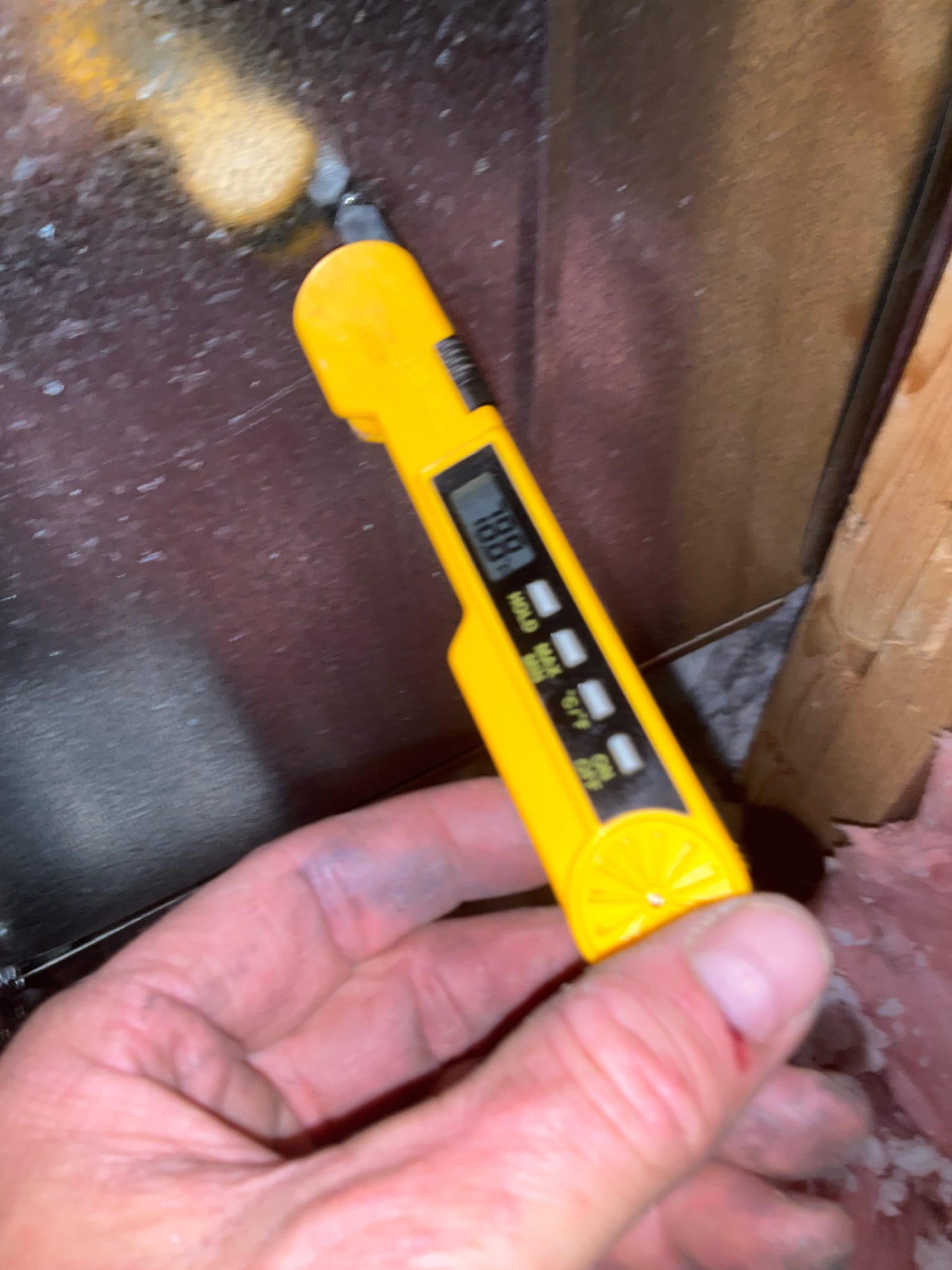 Digital thermometer probe inserted into metal duct measures air temperature during commissioning of the new HVAC system.