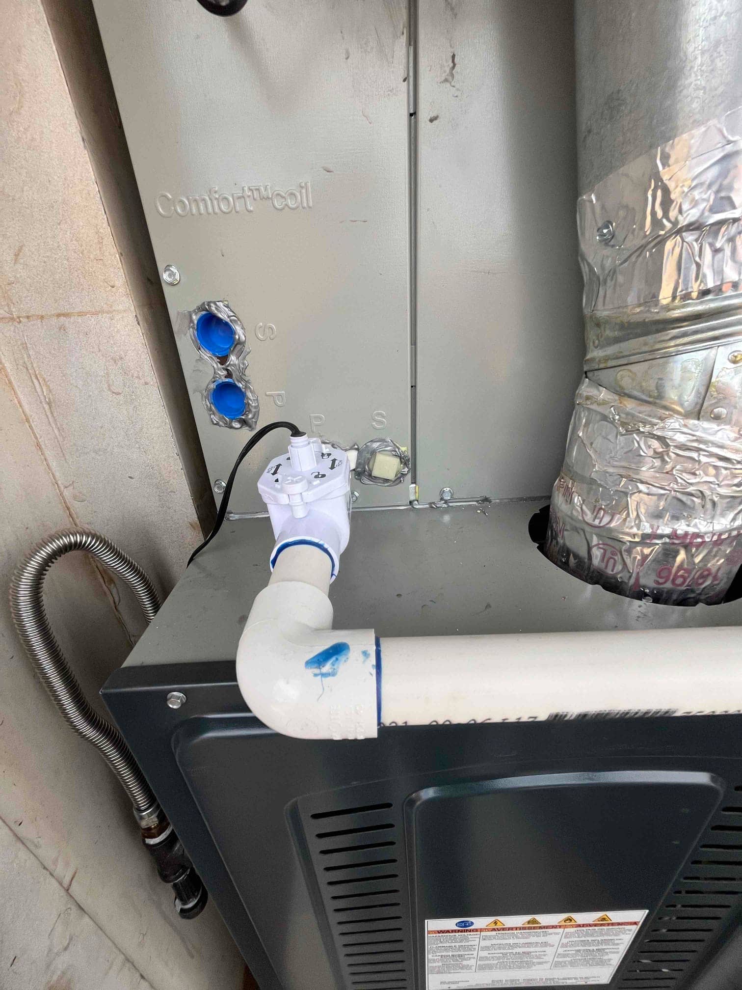 Furnace and evaporator coil assembly with sealed side ports, PVC condensate drain with float switch, and insulated supply duct connection.