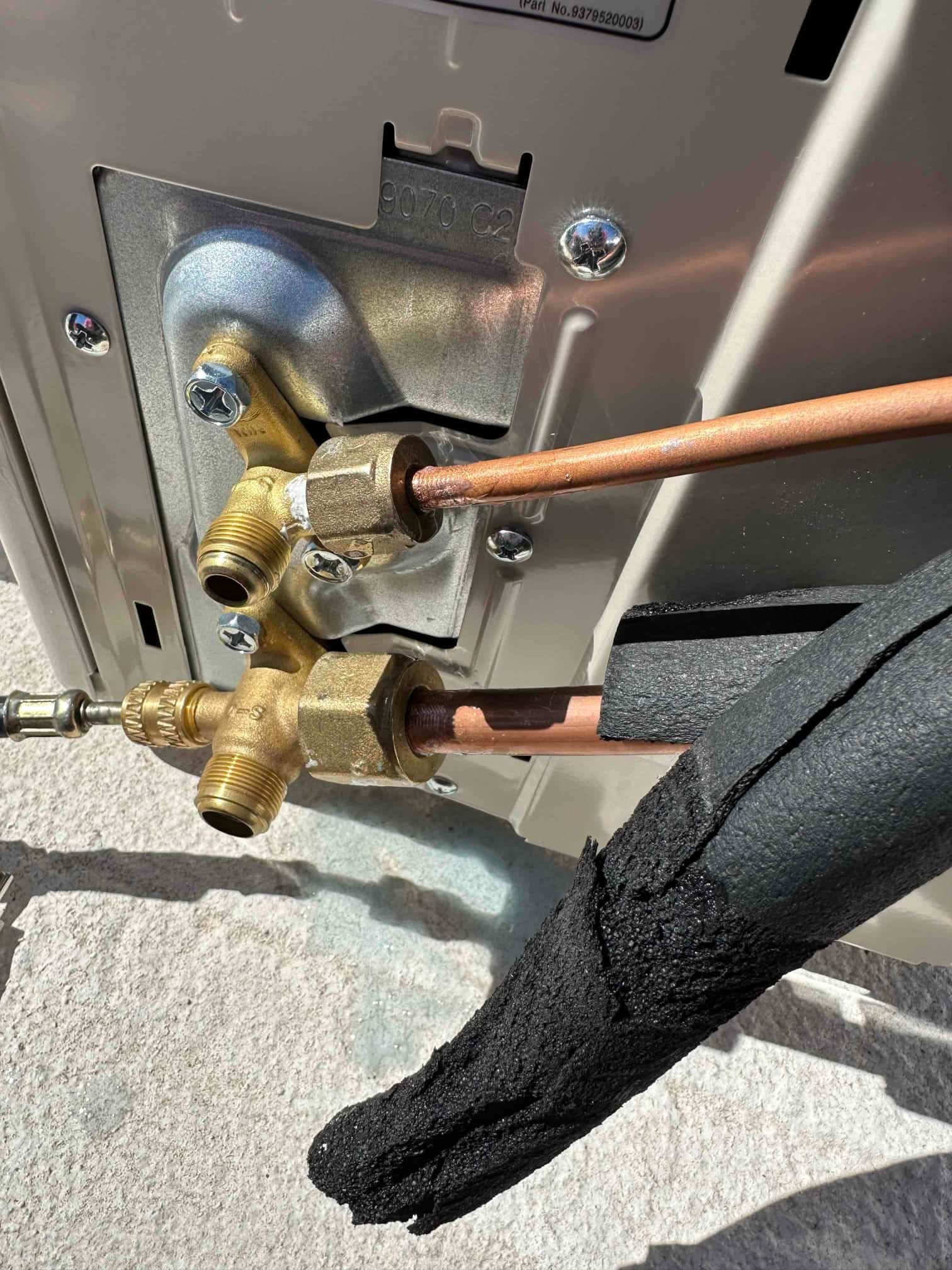 Mini-split service valves connected to new copper line set with insulation partially installed at the outdoor unit.