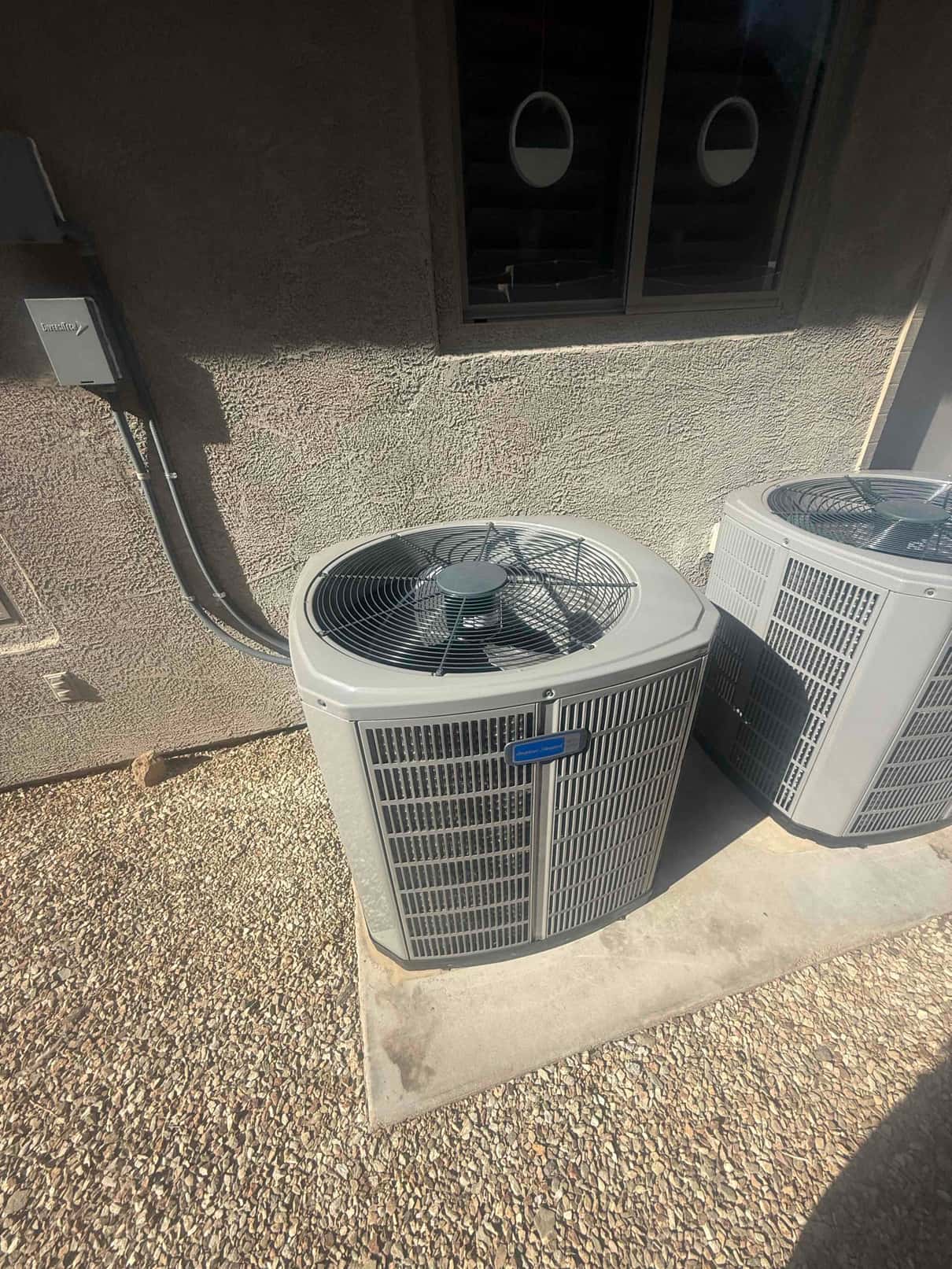 New outdoor condensing unit set on a level concrete pad with weatherproof electrical disconnect and neatly routed conduit.