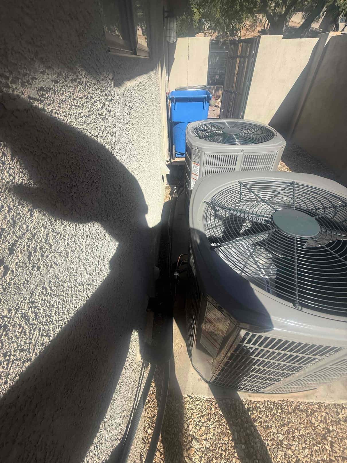 Two outdoor condensers set on pads beside the house with insulated refrigerant lines routed along the wall.