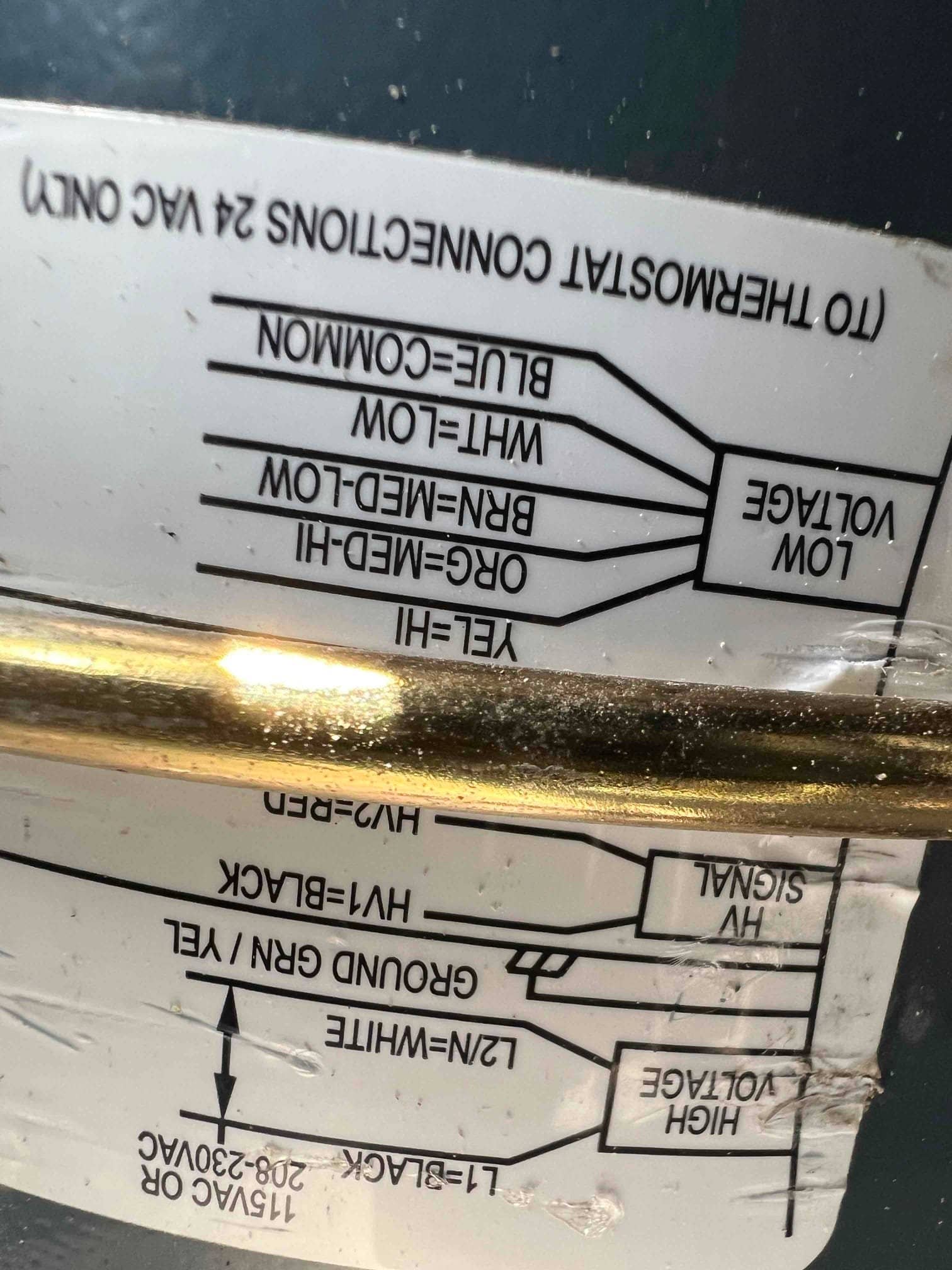 Wiring diagram sticker showing thermostat connections, low-voltage leads, and high-voltage terminals on the interior of the HVAC cabinet.