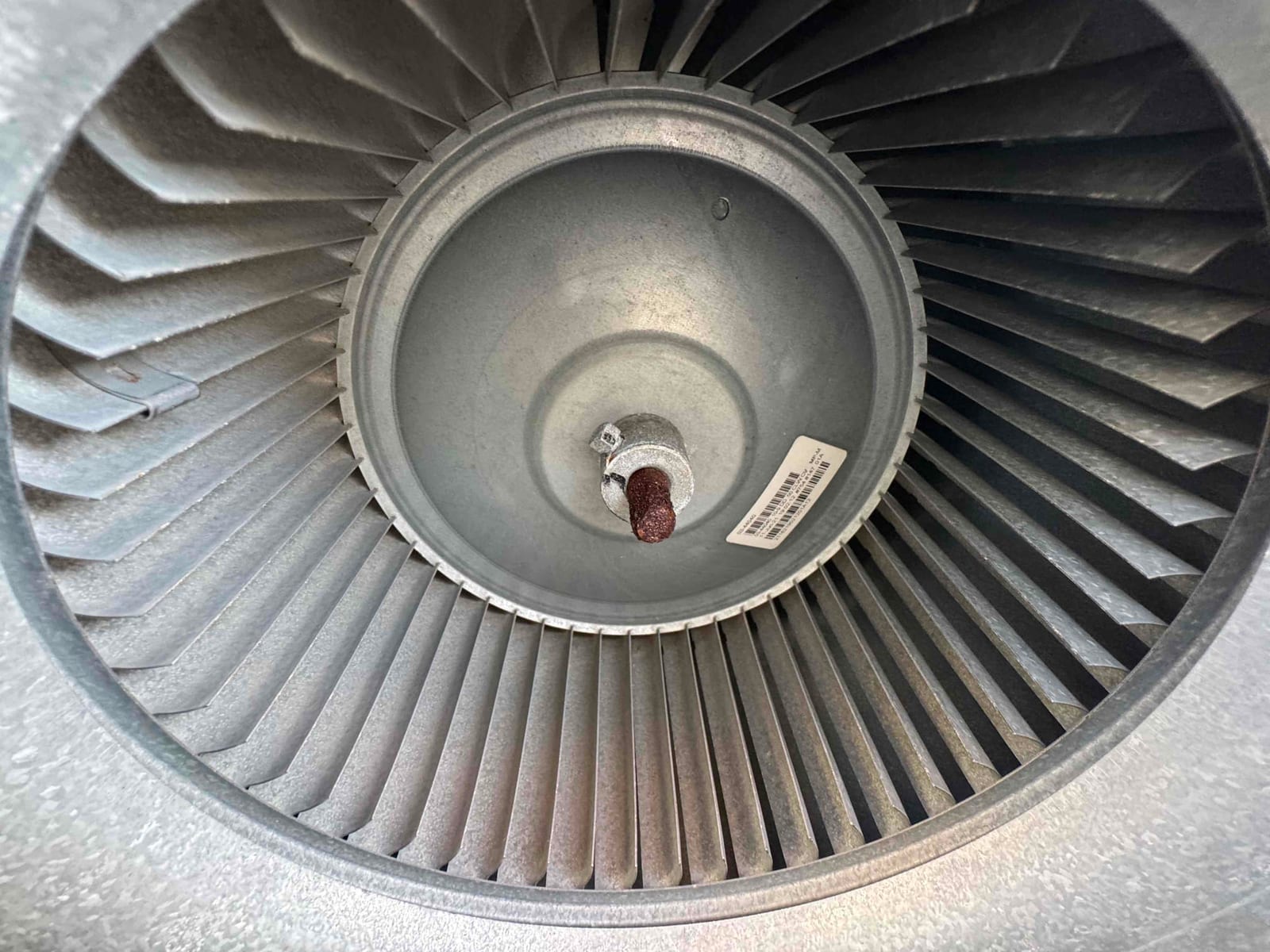 Close-up of a blower wheel and hub assembly, showing clean metal fins and central shaft with retaining hardware.