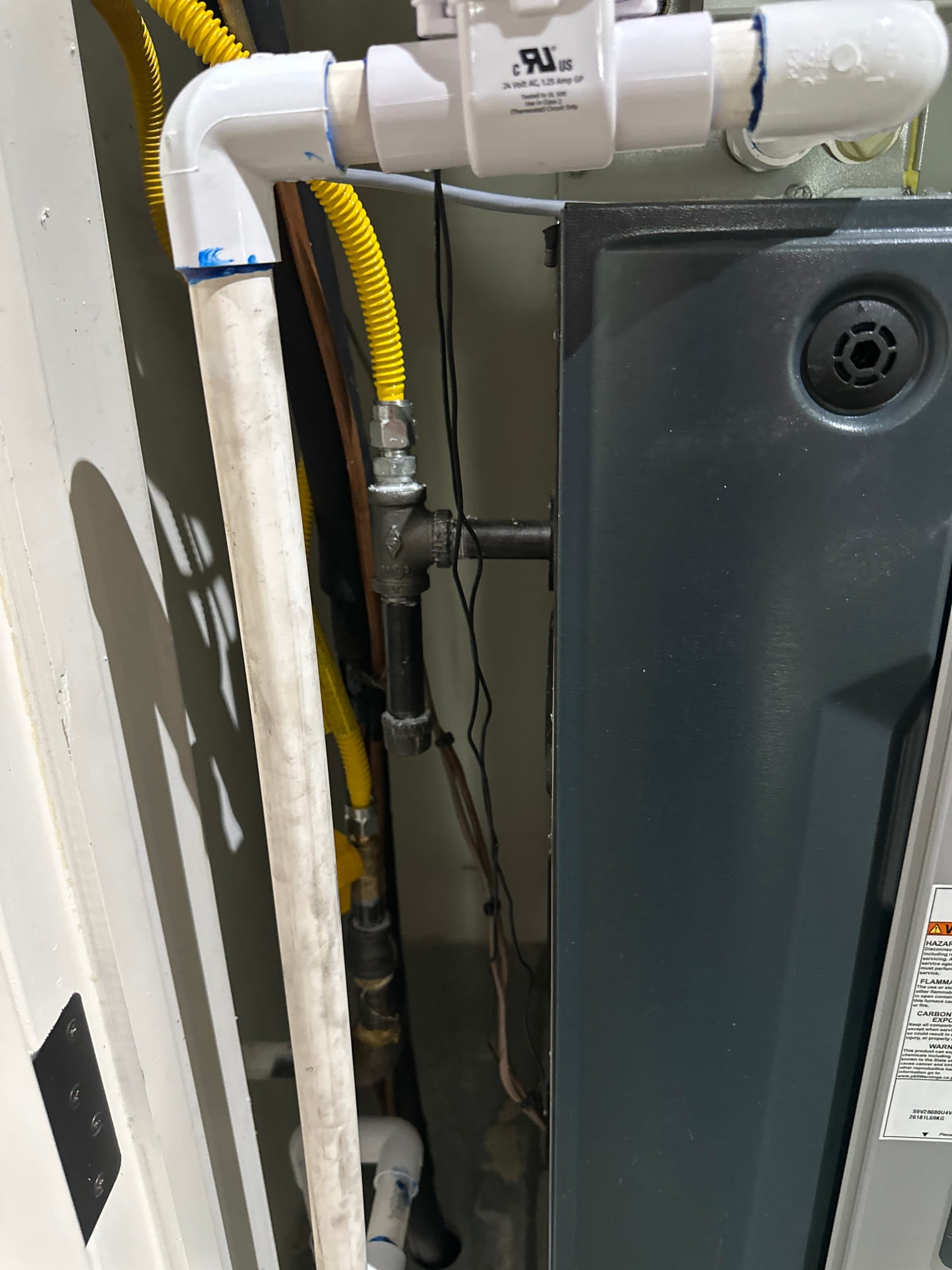 Condensate drain piping, gas flex connector, and furnace cabinet installed with sealed PVC drain assembly and clean routing.