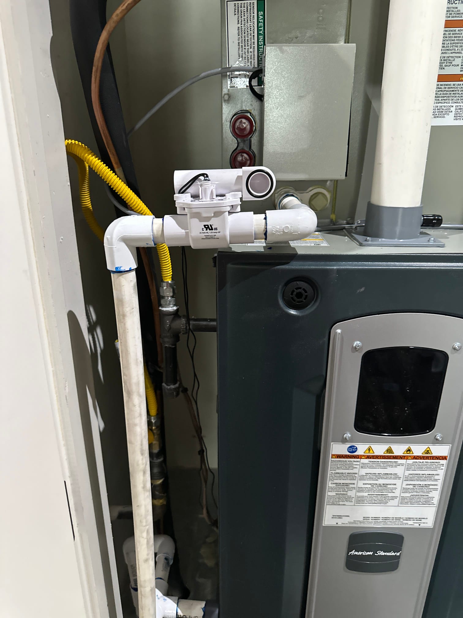 Condensing furnace and evaporator cabinet with new condensate safety switch and PVC drain assembly installed and routed to the floor drain.