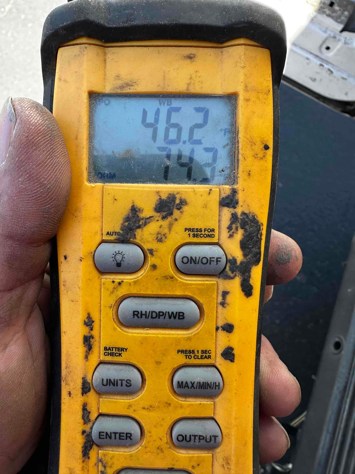 Digital handheld thermometer displays 46.2 degrees with a secondary 74.3 reading during air temperature checks on the new system.