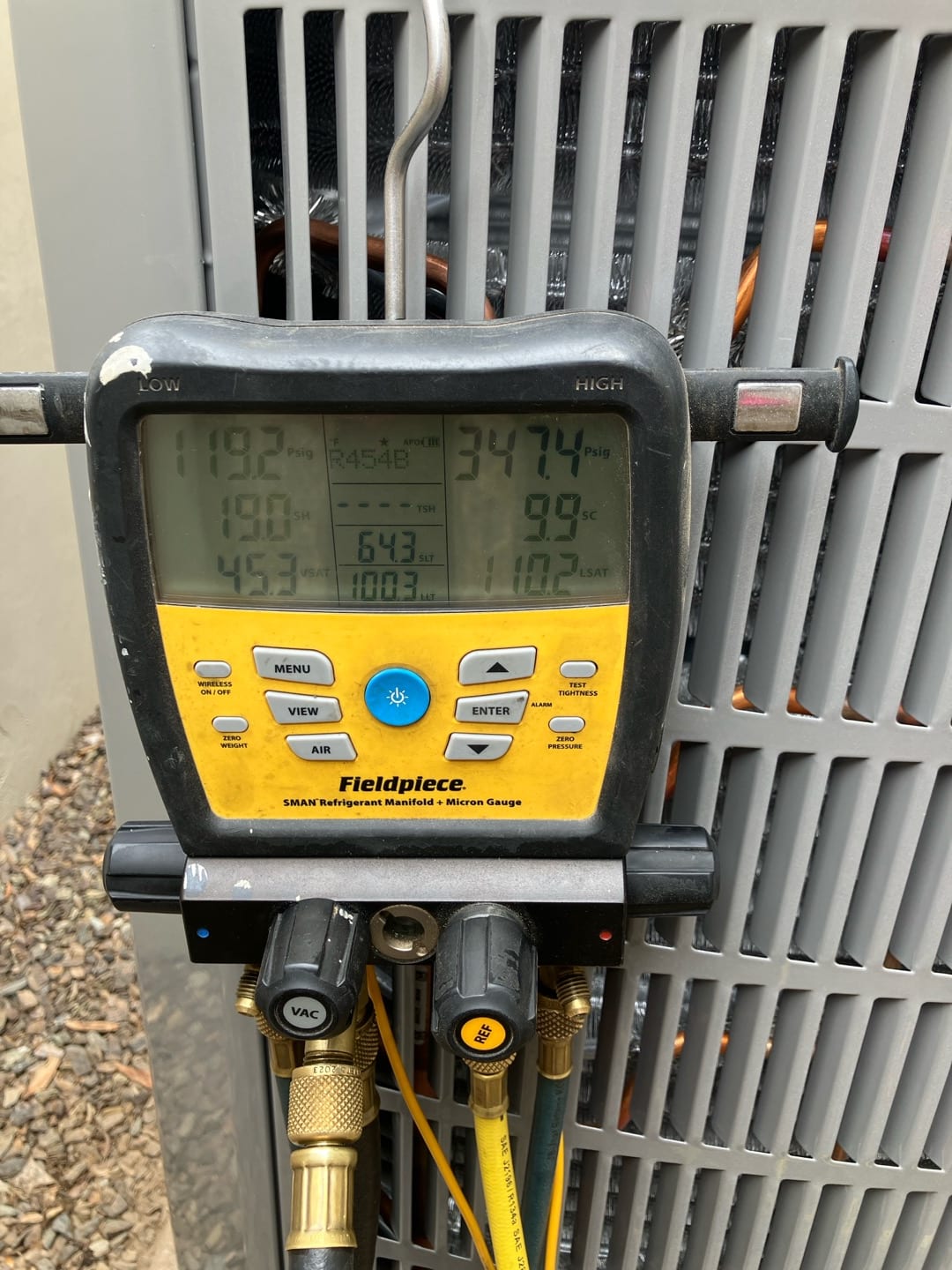 Digital manifold on the outdoor unit shows operating pressures with R-454B selected during system commissioning.