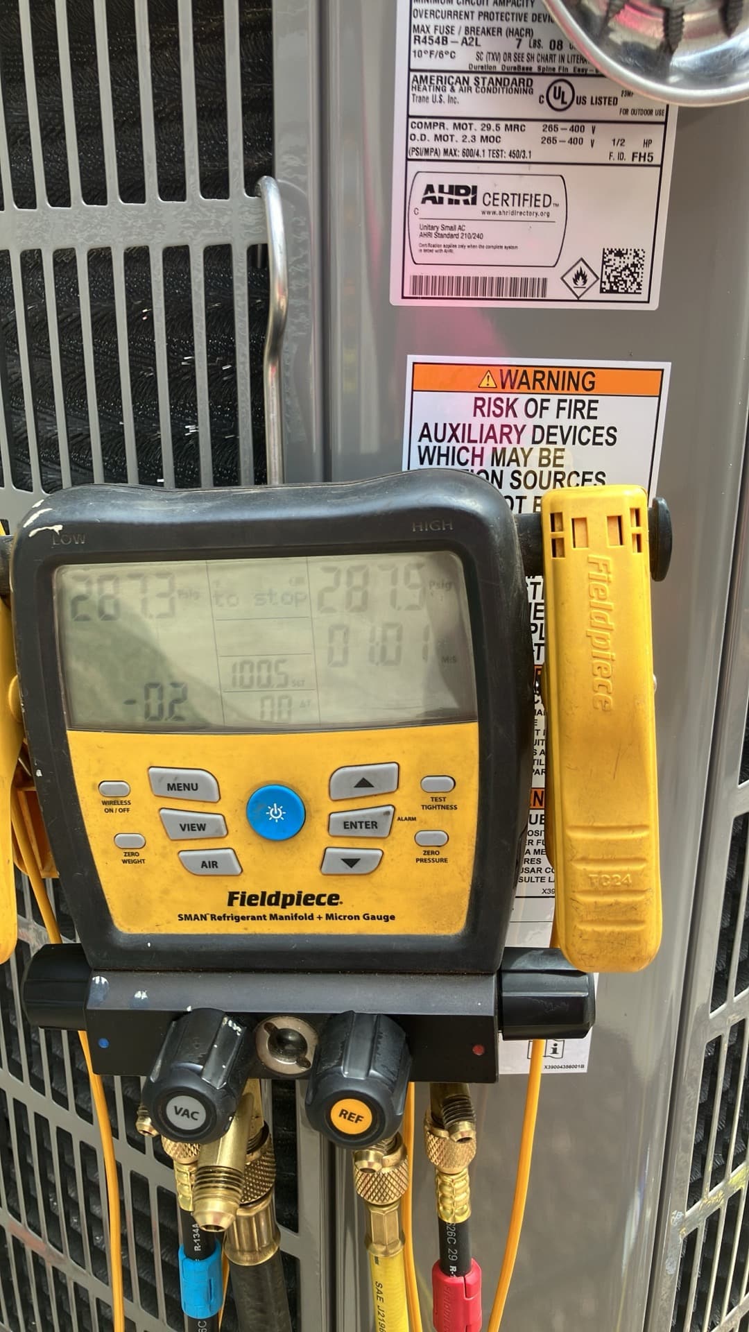 Digital manifold shows equal high pressures on both sides during a nitrogen pressure test at the outdoor condenser.