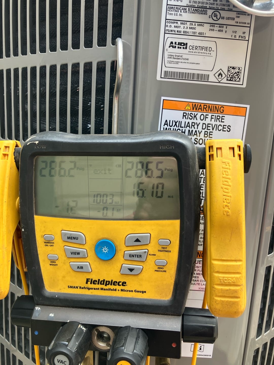 Digital manifold shows both low and high sides holding equal pressure at 286 PSI during a nitrogen pressure test on the outdoor unit.