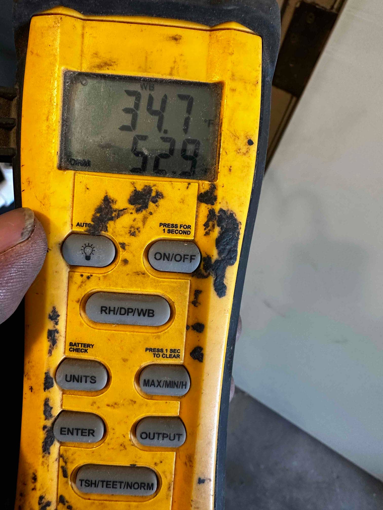 Digital thermometer displays 52.9°F supply air temperature during HVAC system checkout.