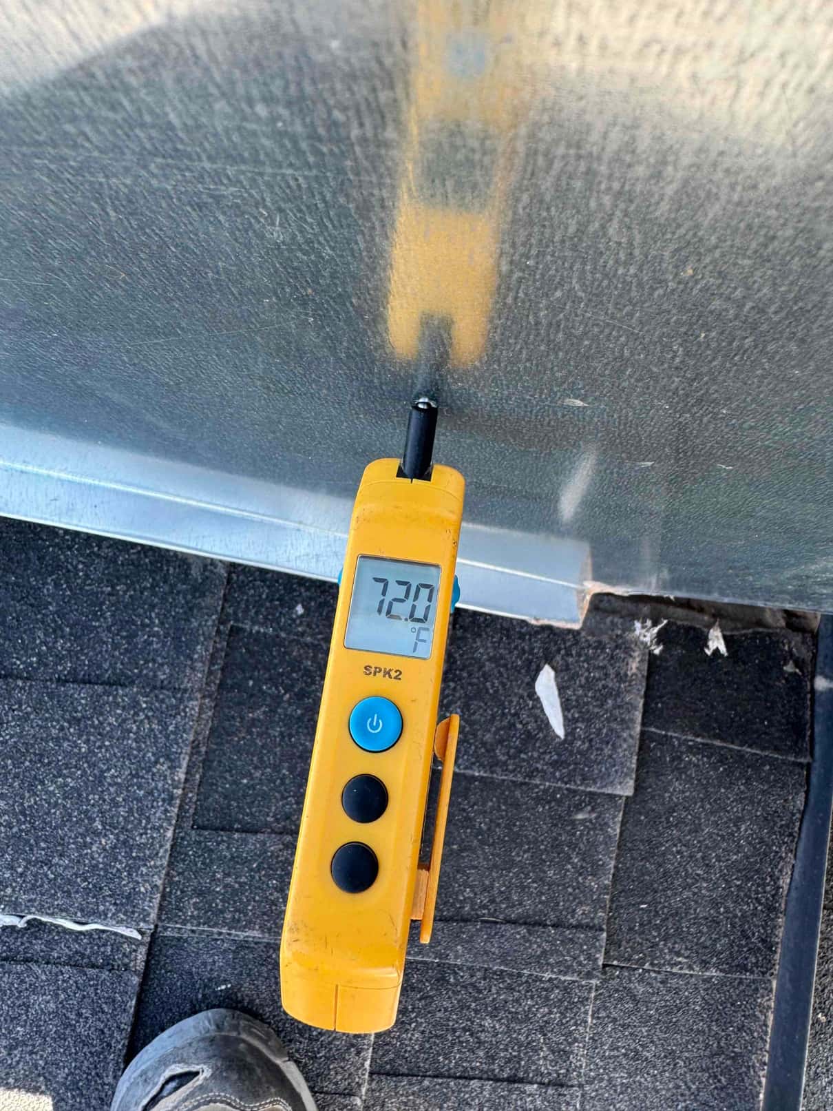 Digital thermometer shows 72.0 °F surface temperature on the outdoor unit housing during air conditioning repair.