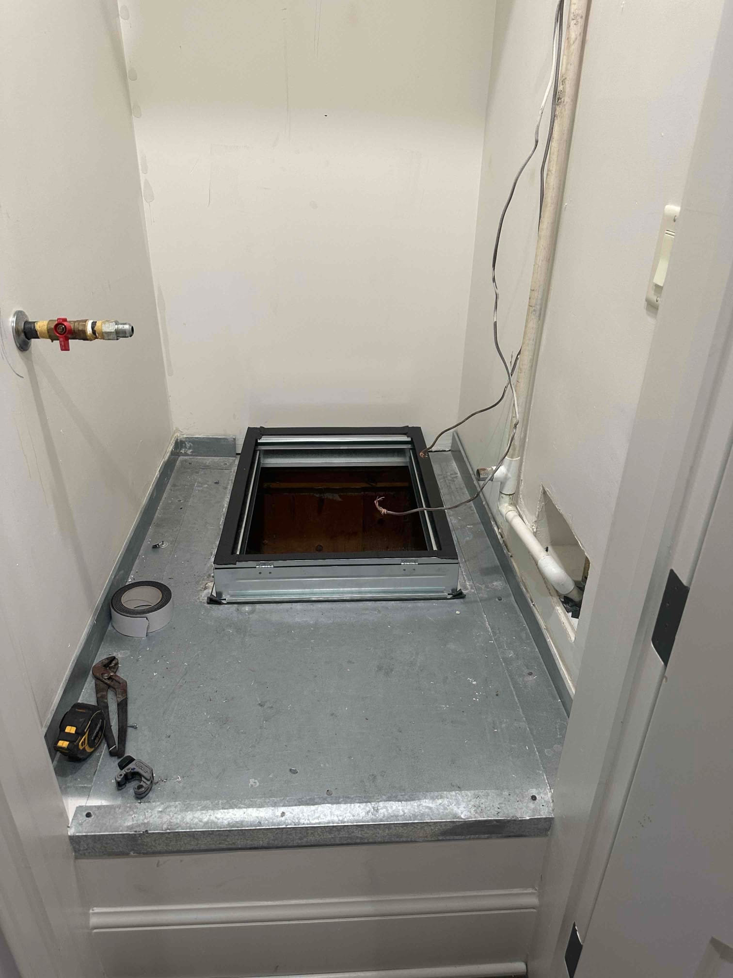 Sheet-metal platform and return plenum opening prepared for new air handler, with gas shutoff valve and condensate drain visible.