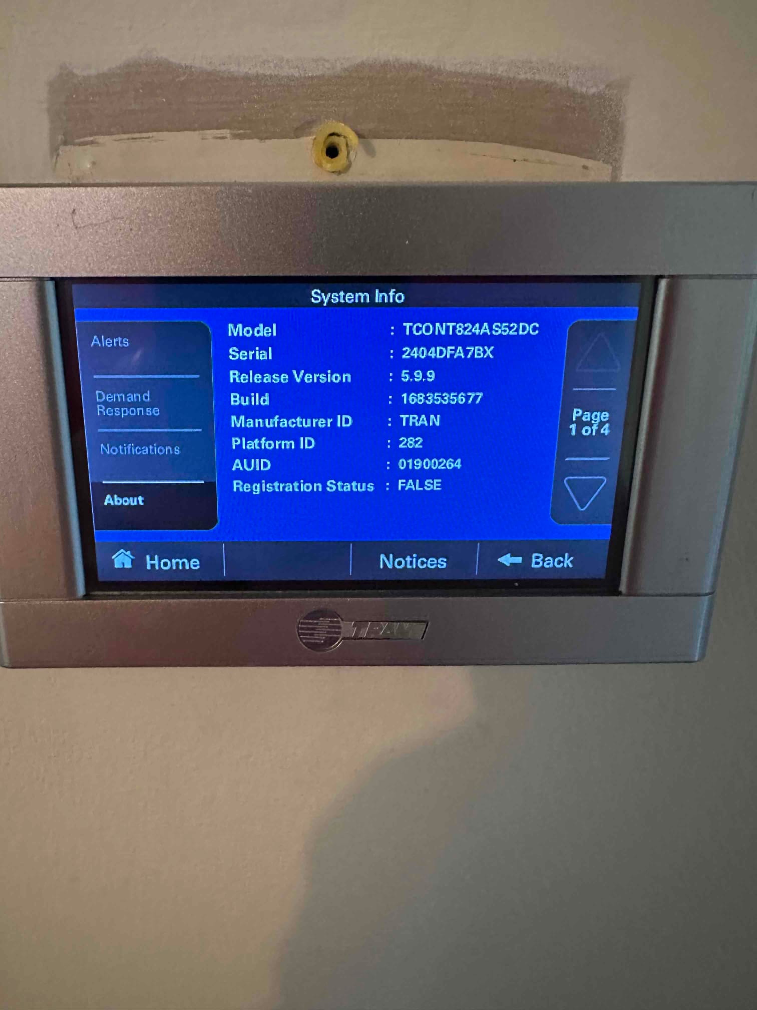 Wall-mounted thermostat touchscreen displays system information during setup at the newly installed HVAC system.
