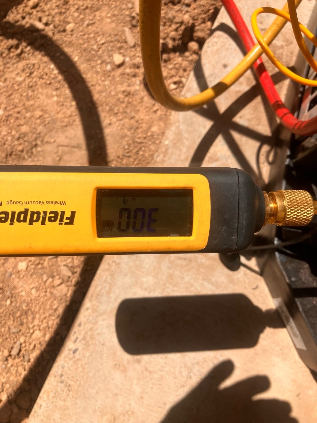 Wireless vacuum gauge connected to the system shows a deep vacuum achieved during evacuation prior to refrigerant charging.