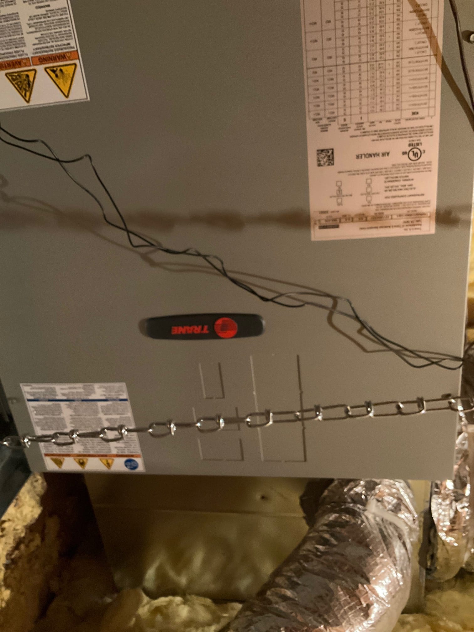 Air handler suspended with hanging straps in the attic, connected to insulated flexible duct and sealed plenum transition.