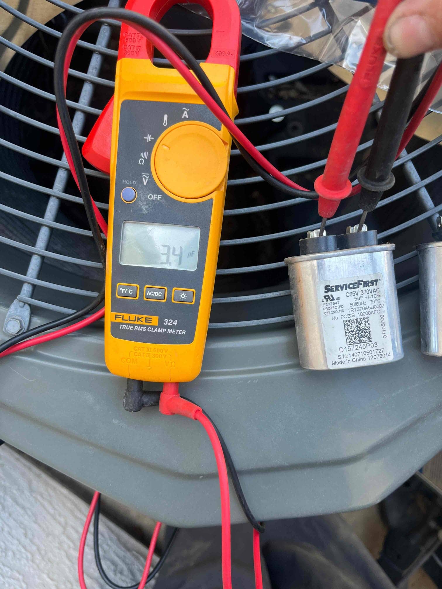 Clamp meter shows 3.4 A while measuring current on a lead connected to the dual-run capacitor.